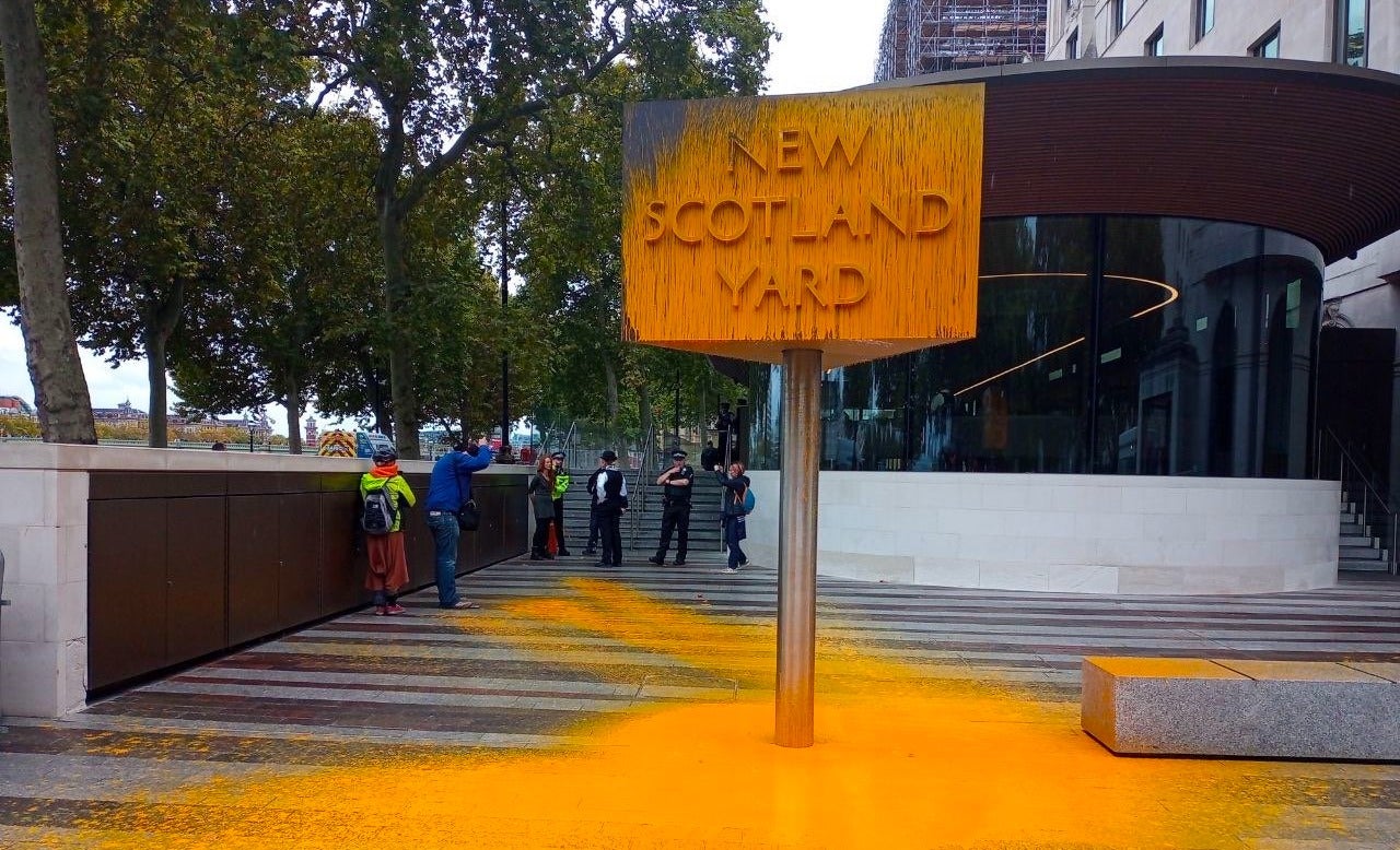 Just Stop Oil supporters spray paint sign at New Scotland Yard