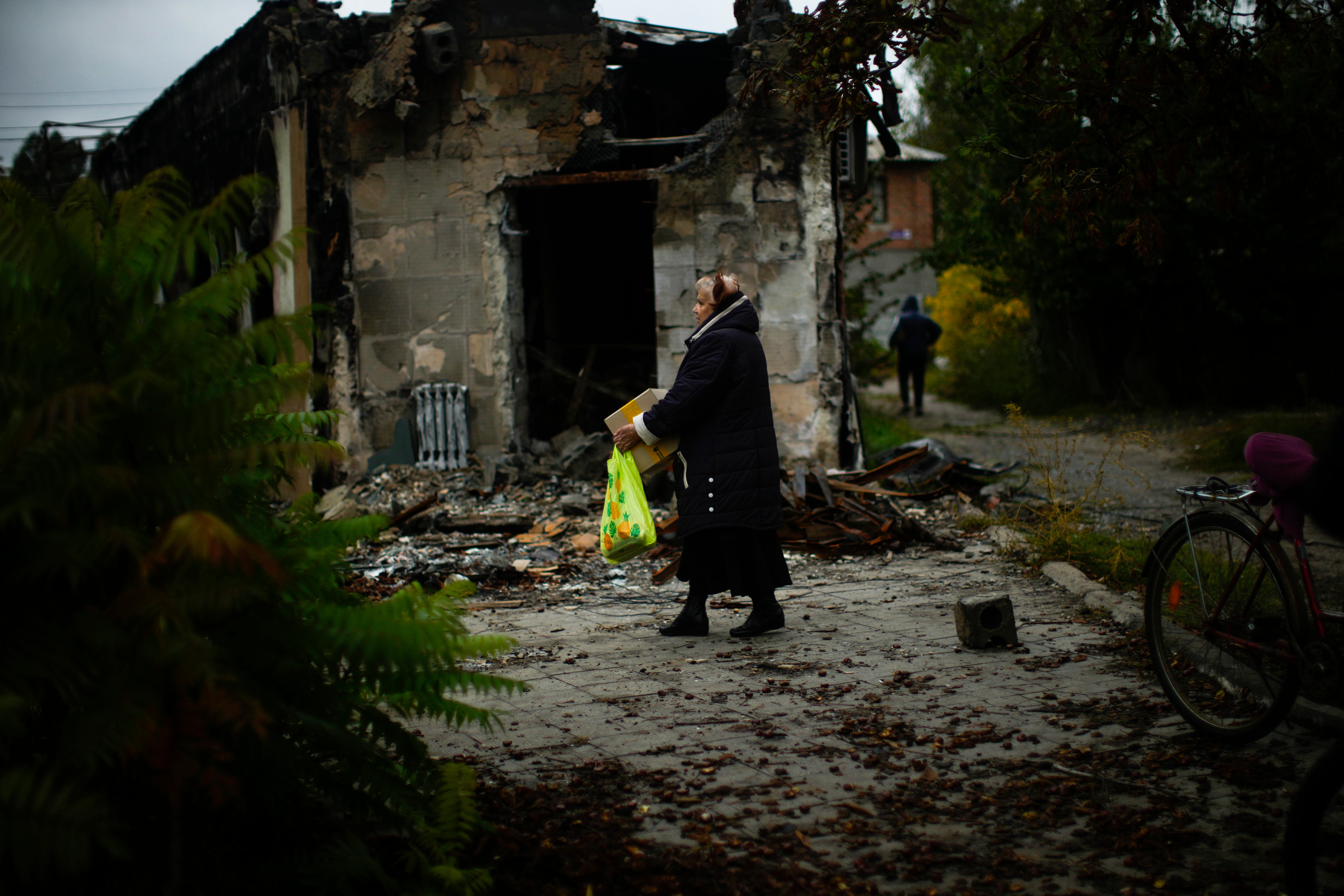 A woman carries a box with food as locals receive humanitarian goods in Sviatohirsk, Ukraine, Tuesday (Francisco Seco/PA)