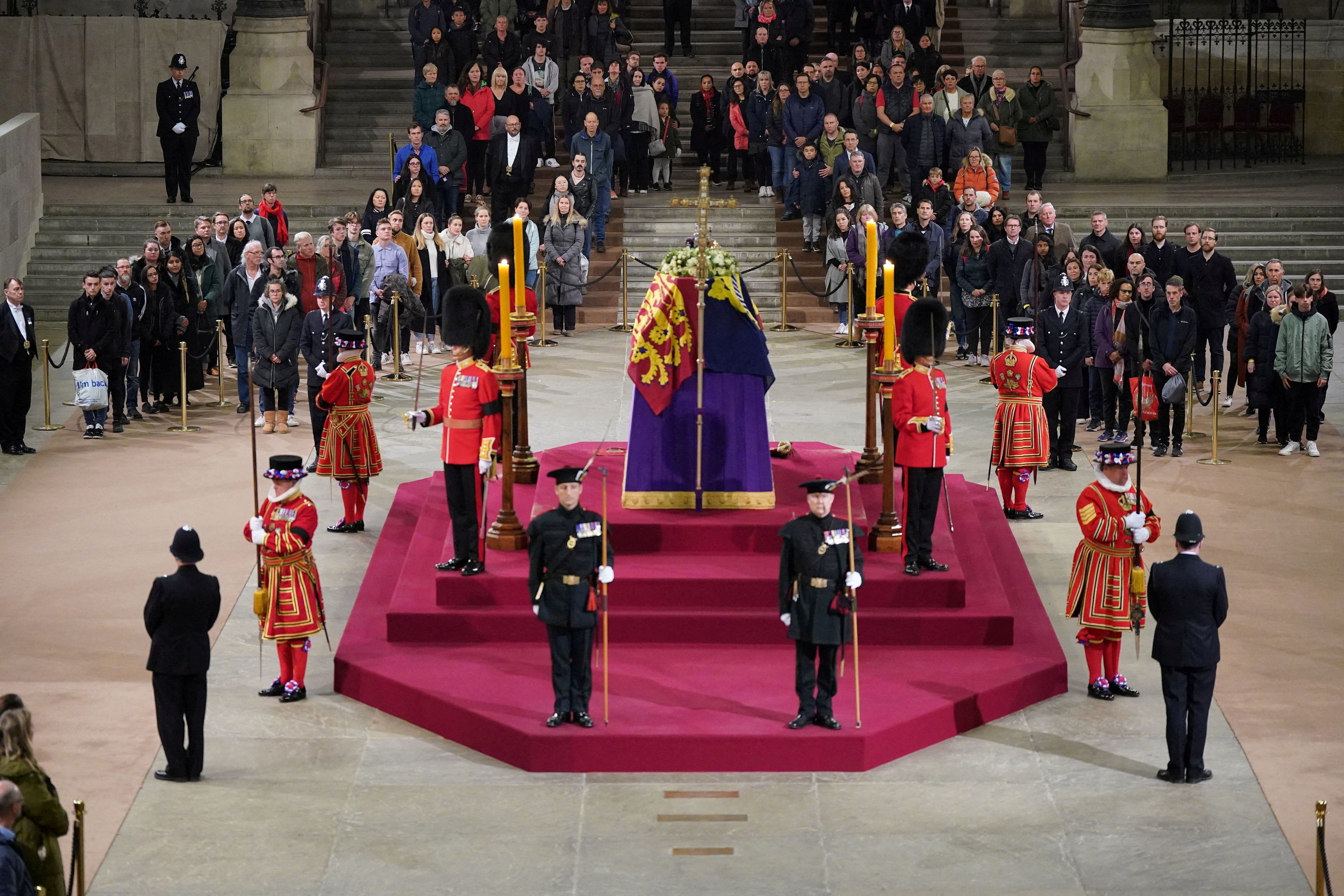 The final members of the public pay their respects at the coffin of Queen Elizabeth II, draped in the Royal Standard with the Imperial State Crown and the Sovereign's orb and sceptre, lying in state on the catafalque in Westminster Hall, at the Palace of Westminster