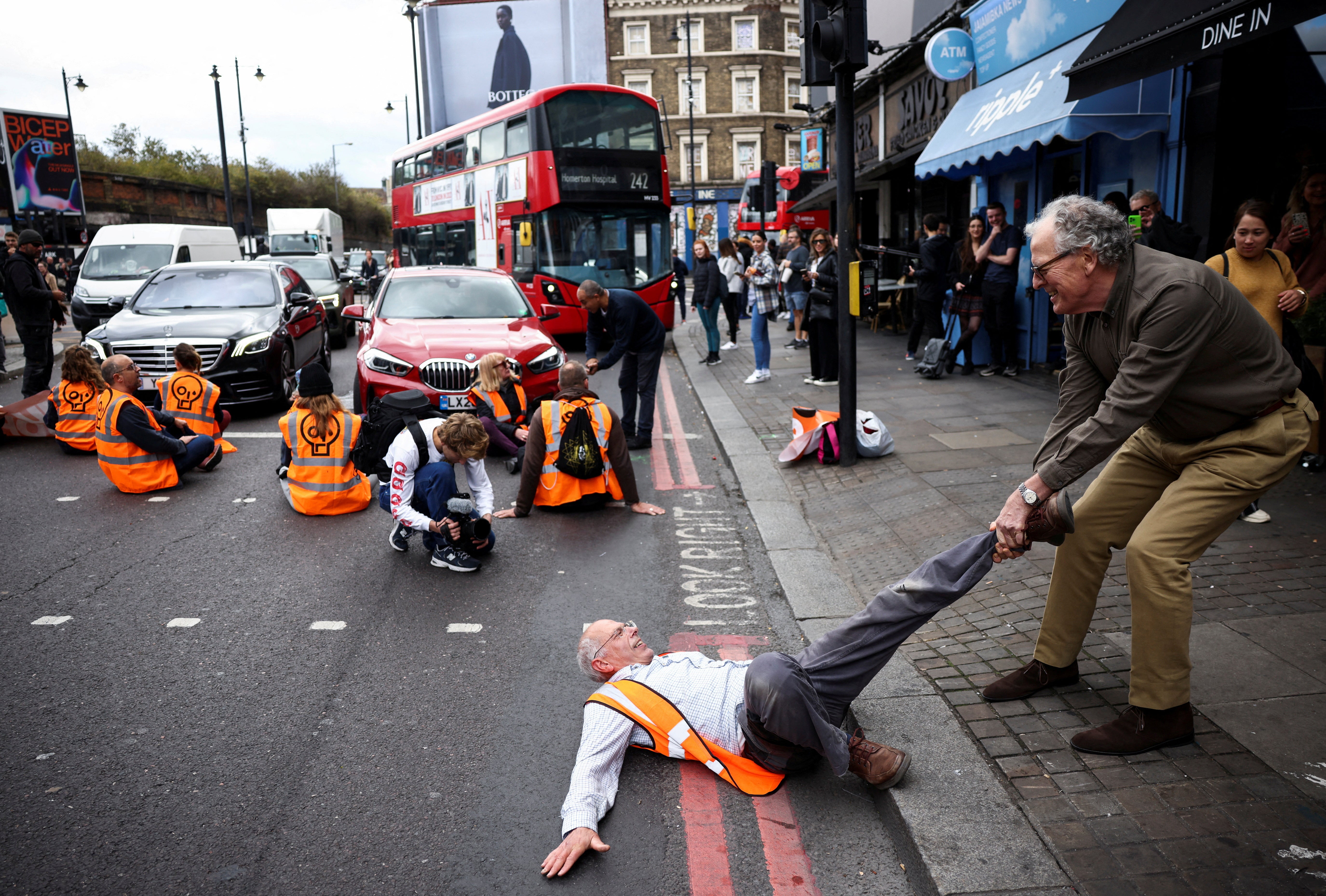 Un miembro del público arrastra a un activista que está bloqueando la carretera durante una protesta de "Just Stop Oil", en Londres, Gran Bretaña.