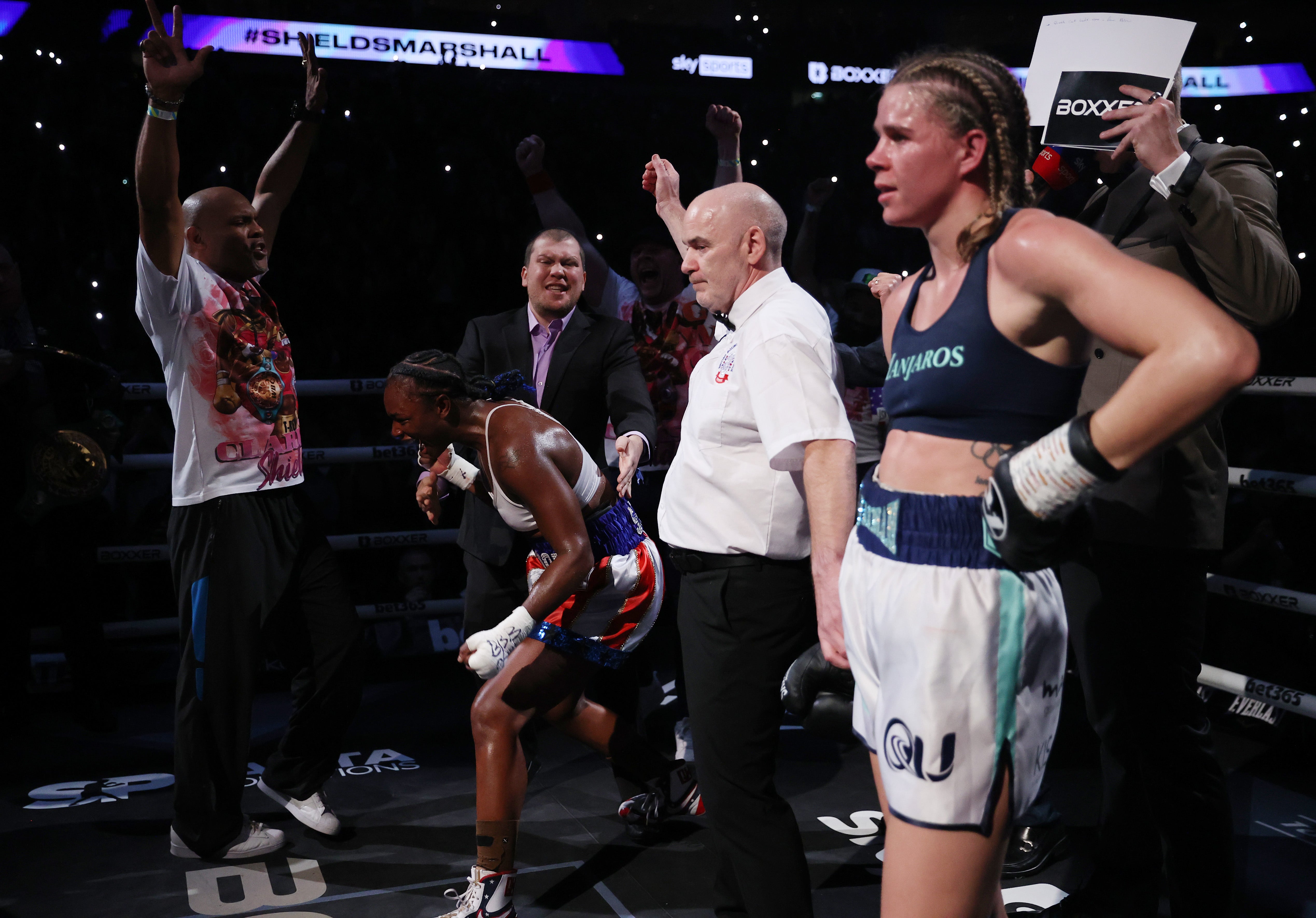 Claressa Shields celebrates as Savannah Marshall looks on