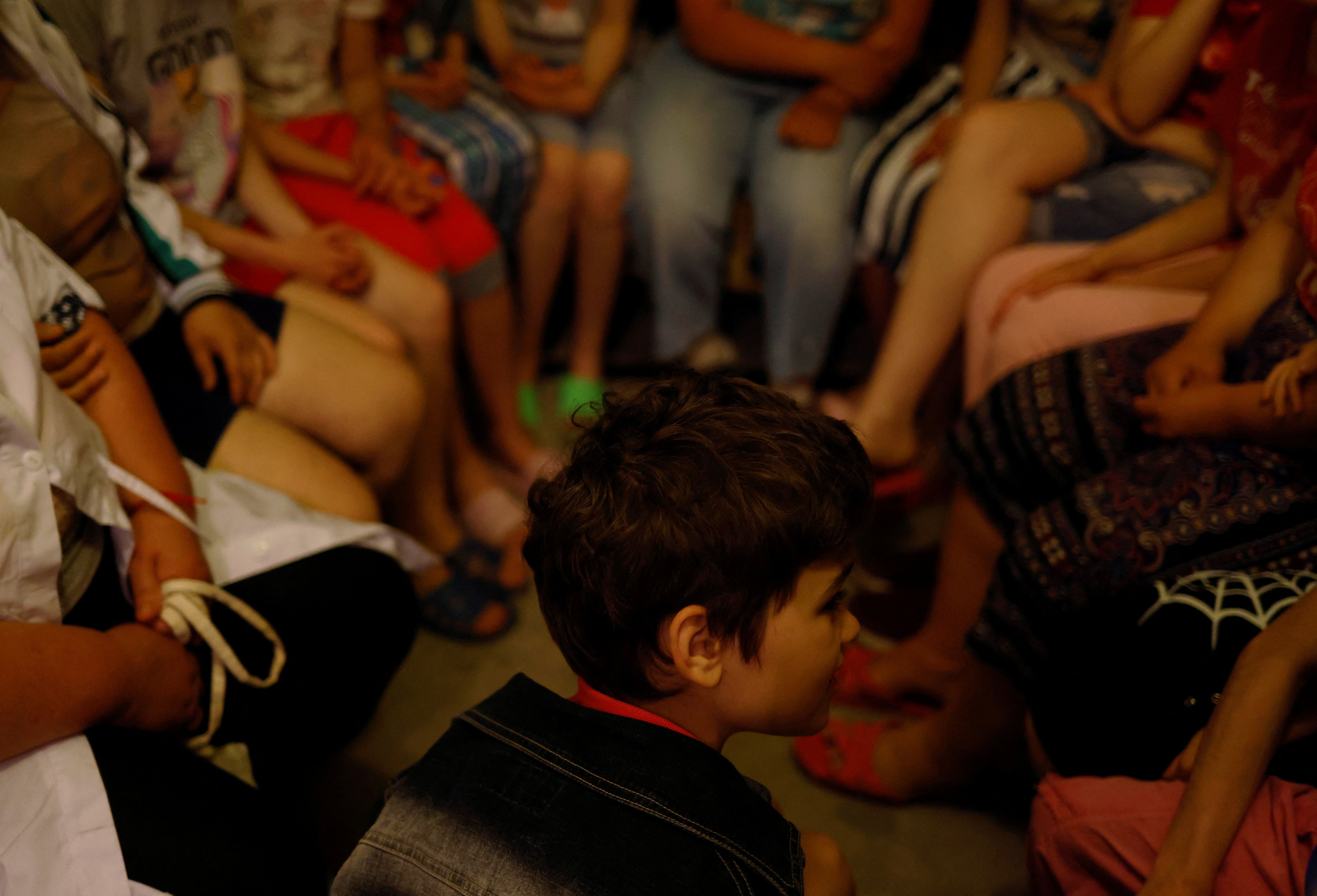 Tanya sits with other children in the shelter