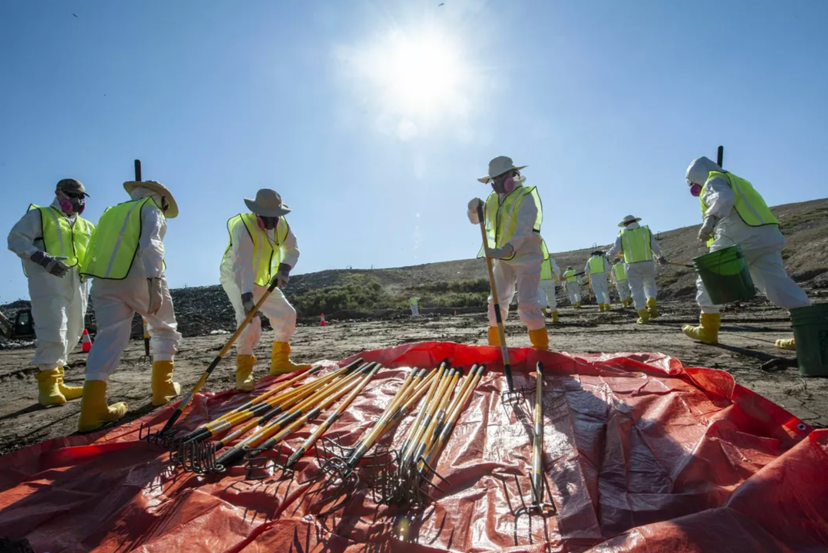 Crew members are seen collecting rakes to dig through the landfill in their search for Quinton