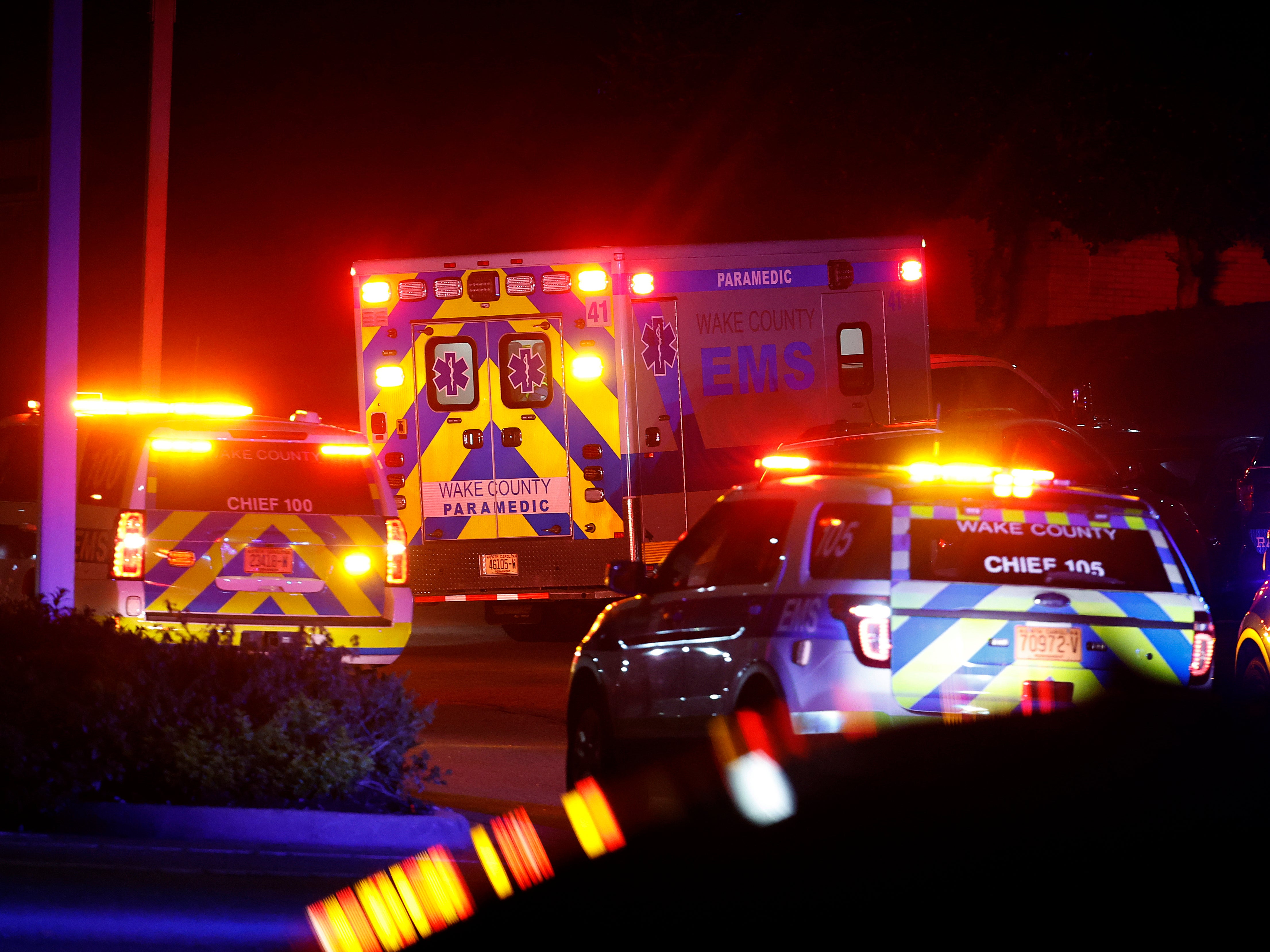 An ambulance believed to be carrying a shooting suspect arrives at Wake Medical Center Emergency Room in Raleigh, N.C., Thursday, Oct. 13, 2022, surrounded by police