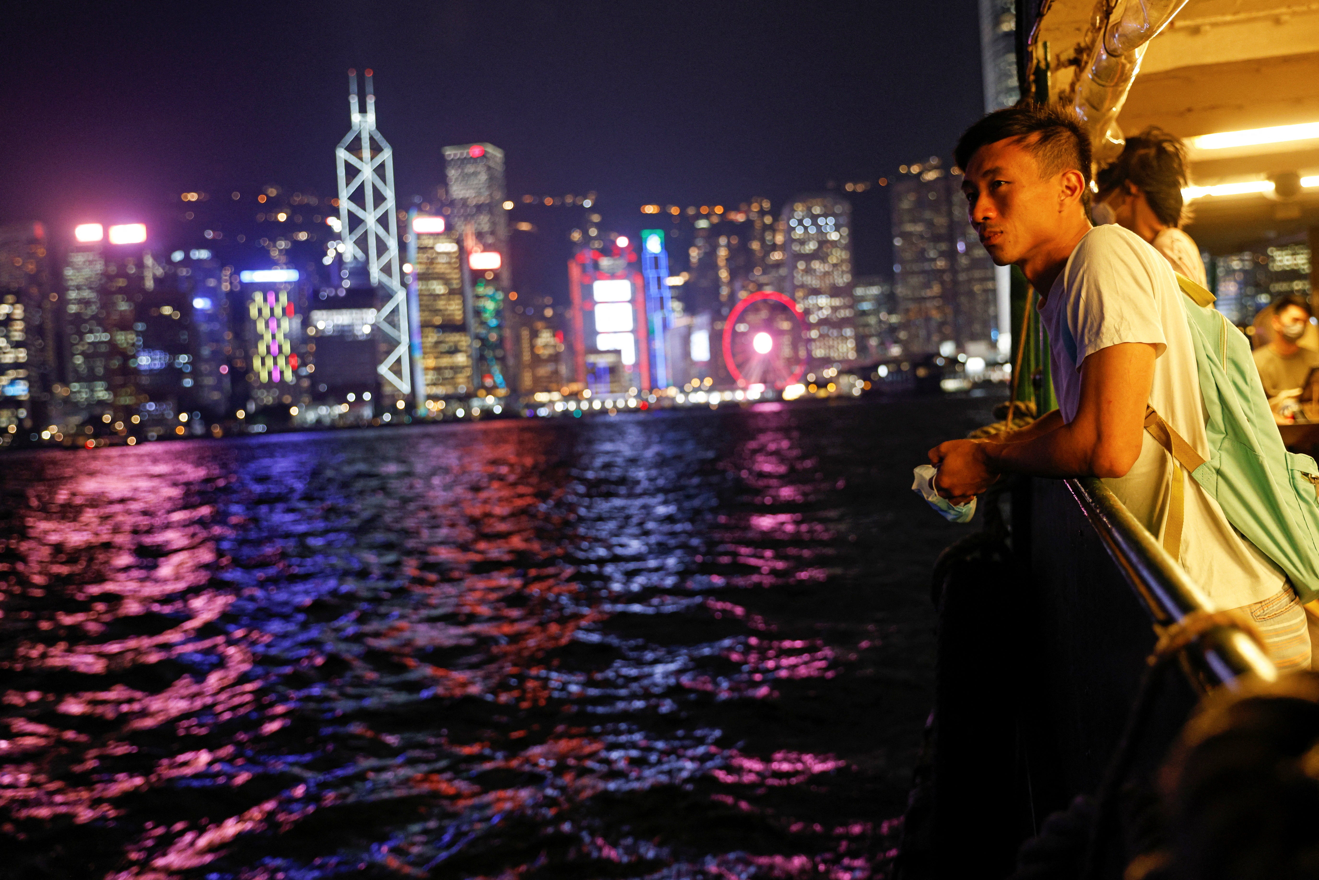 Craftsman Jesse Yu, 32, crosses on a ferry from Victoria Harbour, with the financial district seen in the background, in Hong Kong