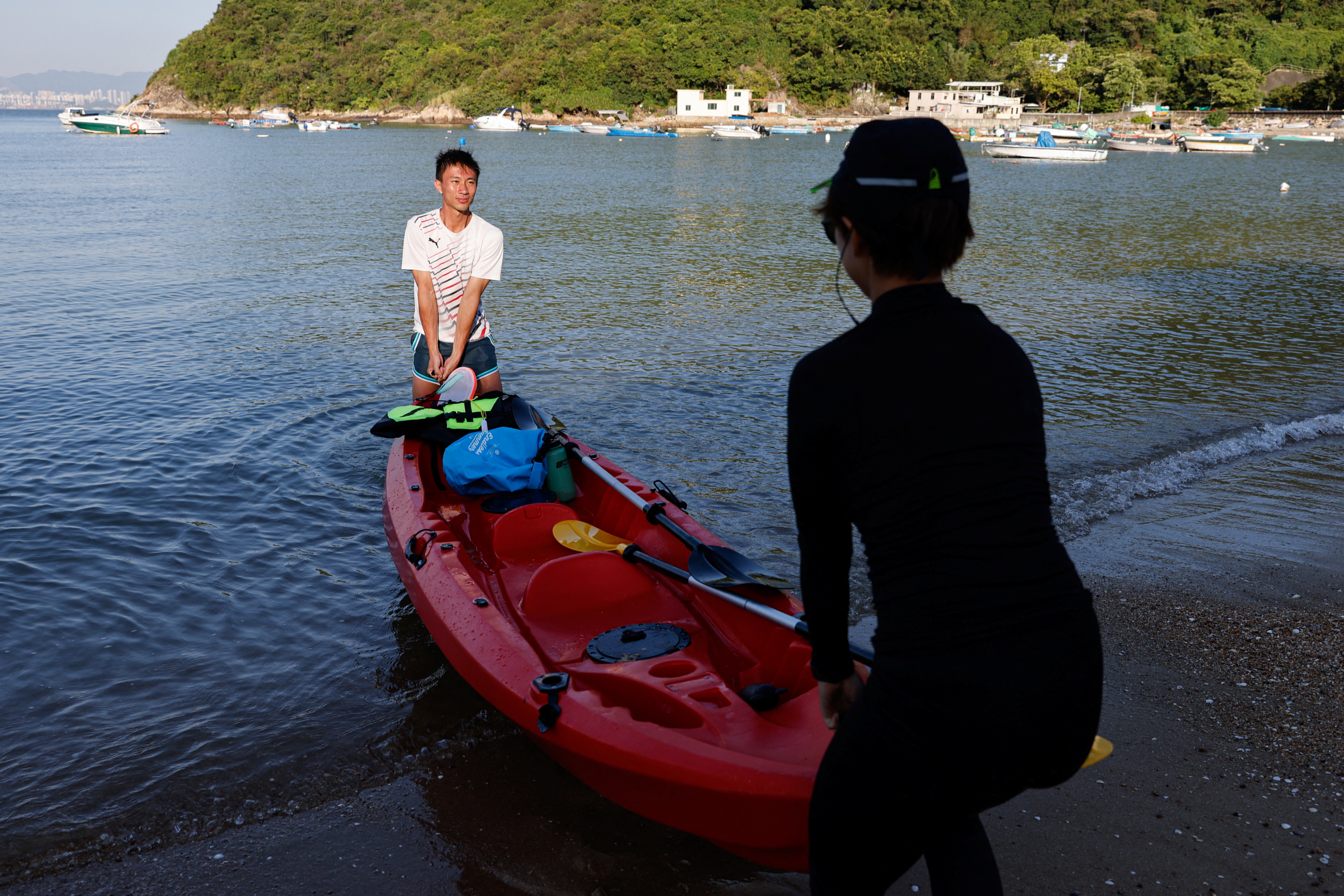 Jesse Yu and yoga teacher Zero Chan, 36, move a canoe onto the beach on Peng Chau island