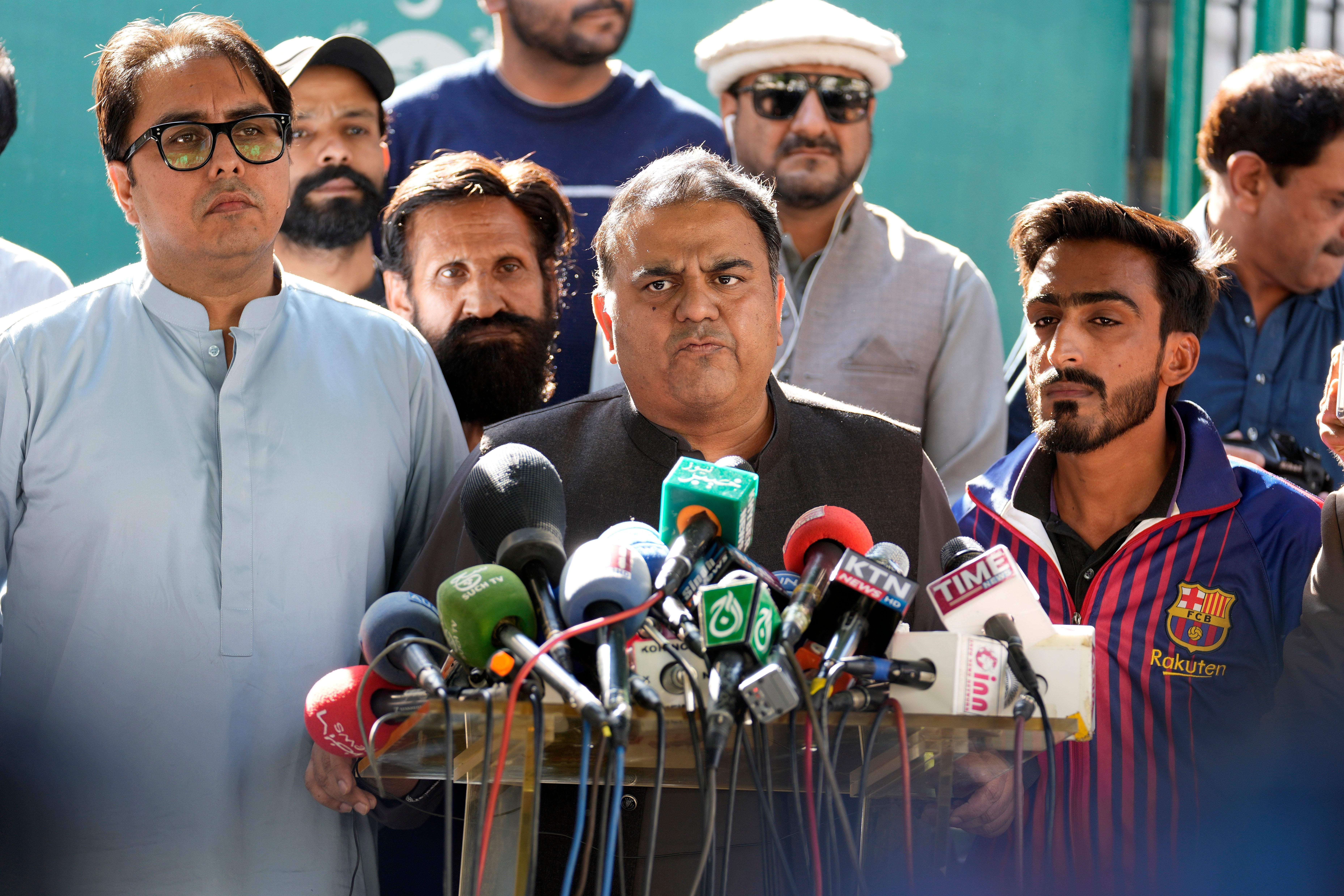 Fawad Chaudhry (centre), a senior member of former prime minister Imran Khan’s party, addresses the media outside the Election Commission