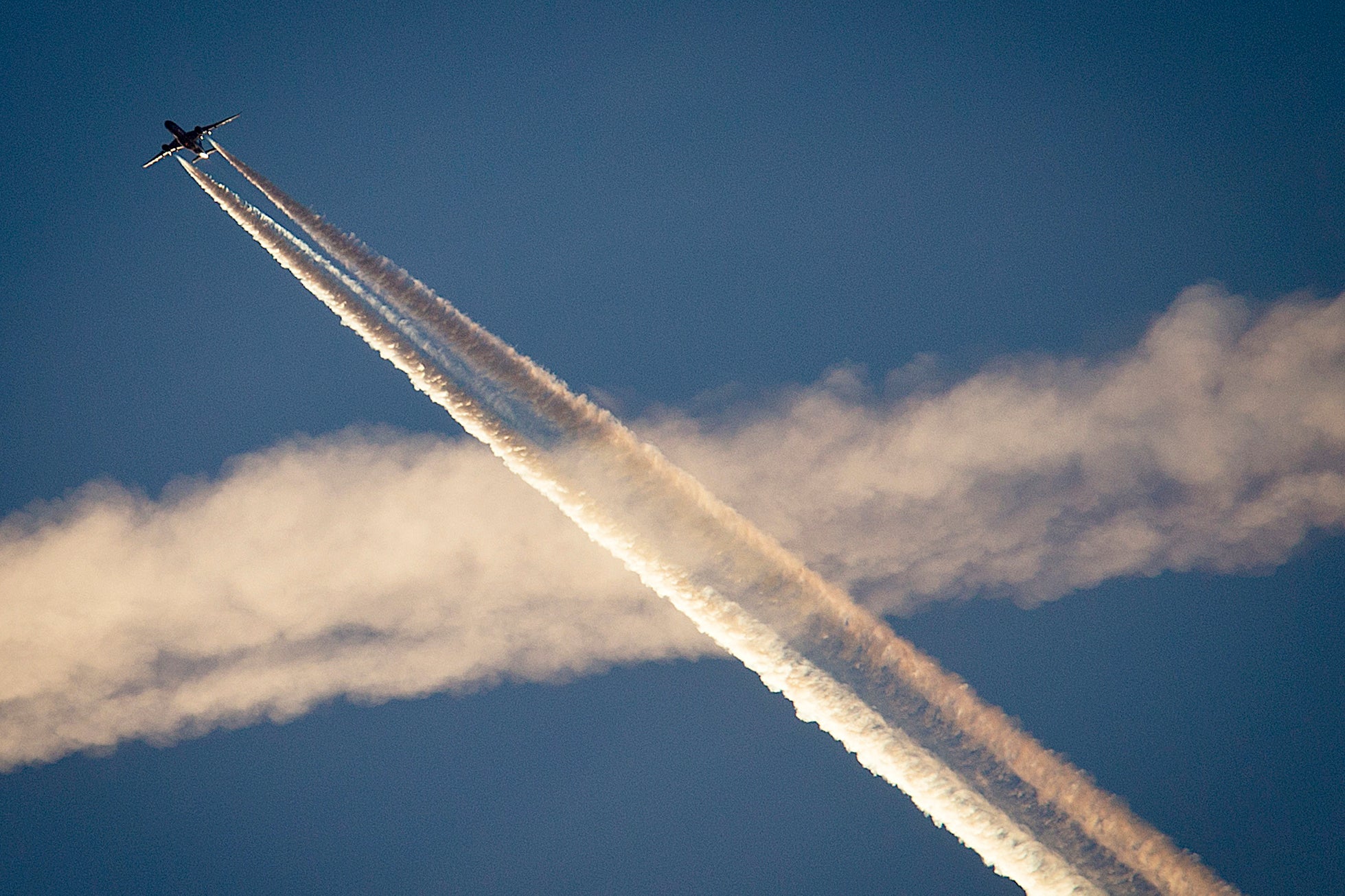 An aircraft crosses the vapor trails of another plane over Frankfurt, Germany, on 19 April, 2018