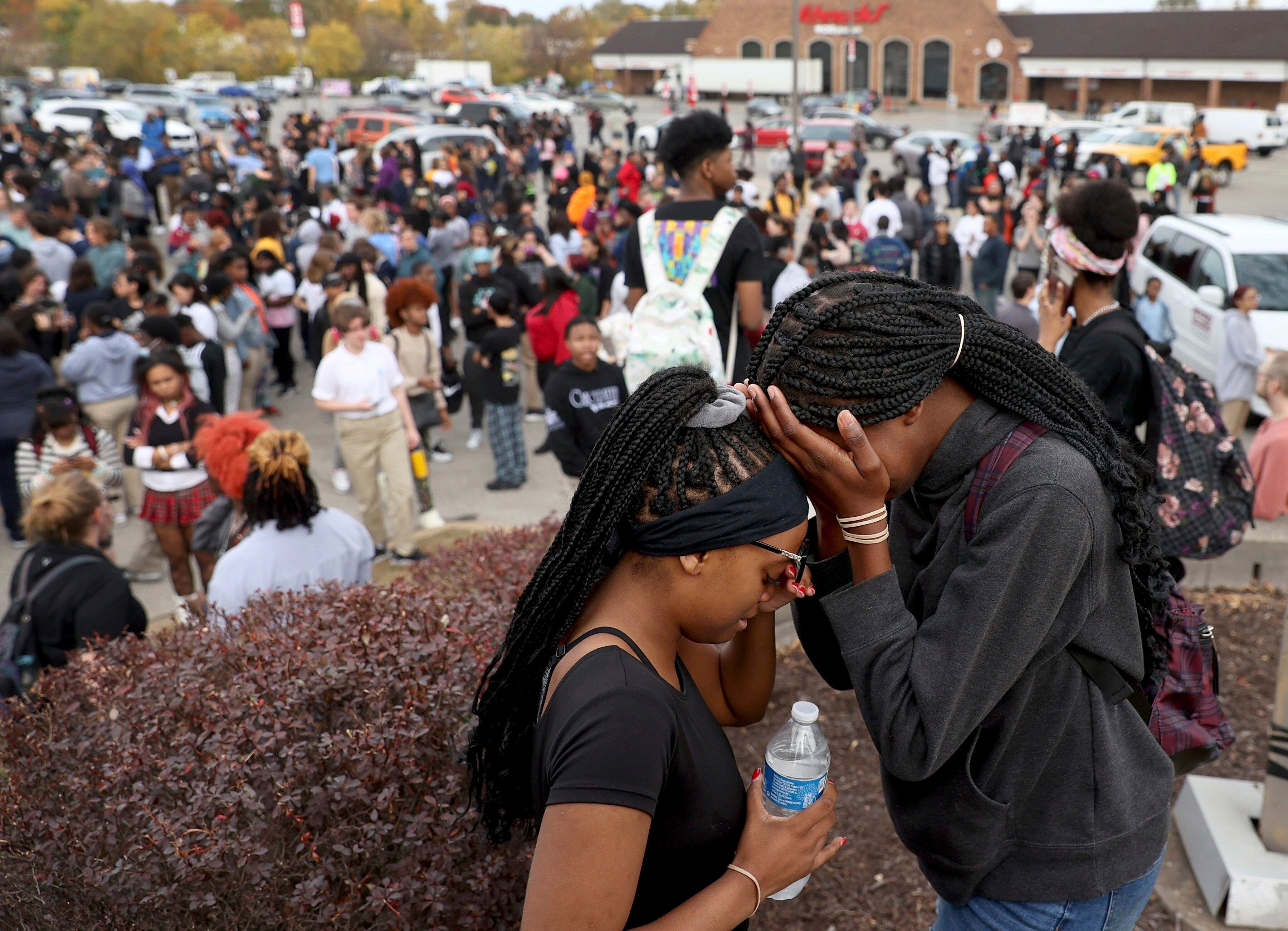 Students stand in a parking lot near the Central Visual & Performing Arts High School