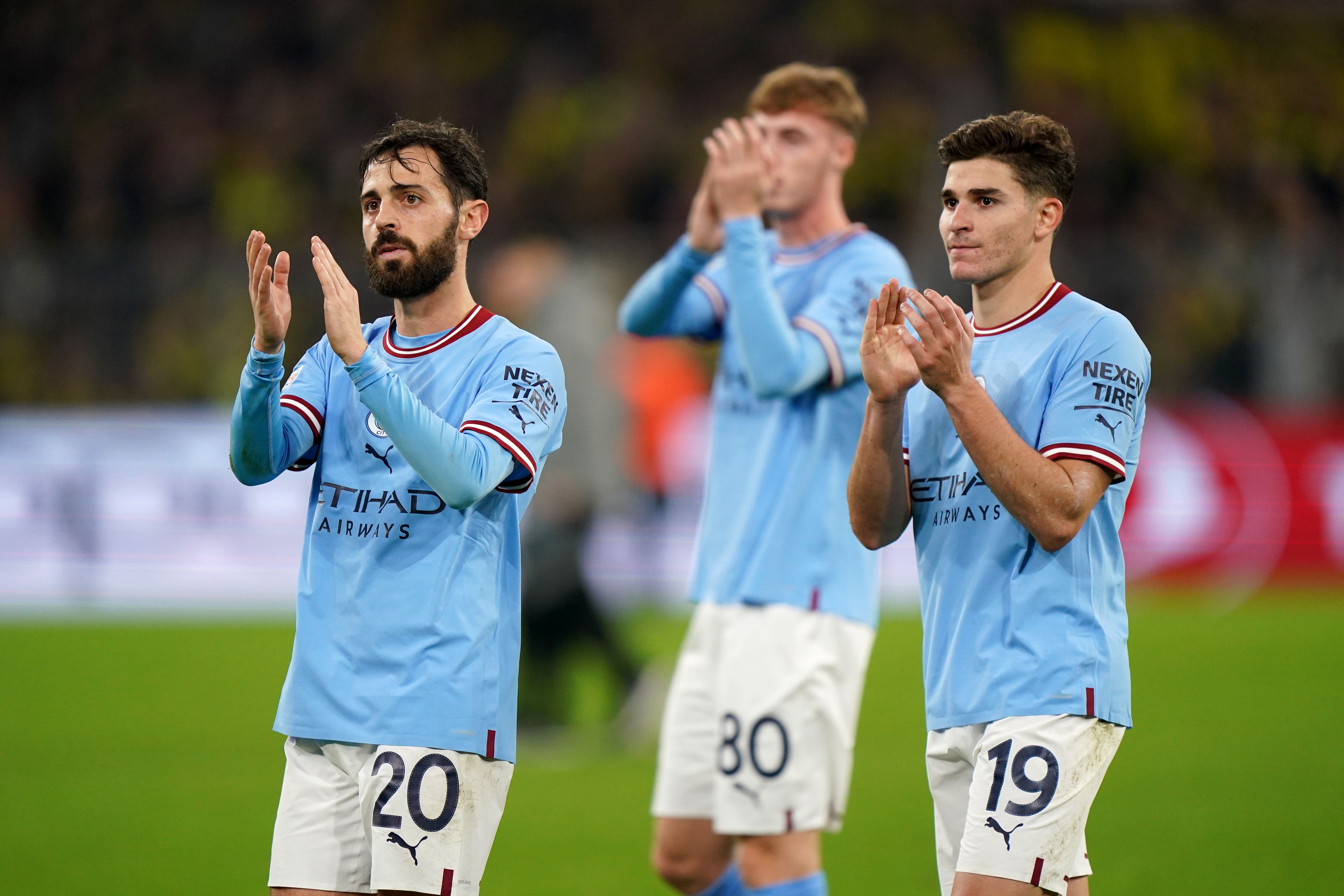 Manchester City’s Bernardo Silva and Julian Alvarez applaud their fans after their goalless draw in Dortmund (Tim Goode/PA)