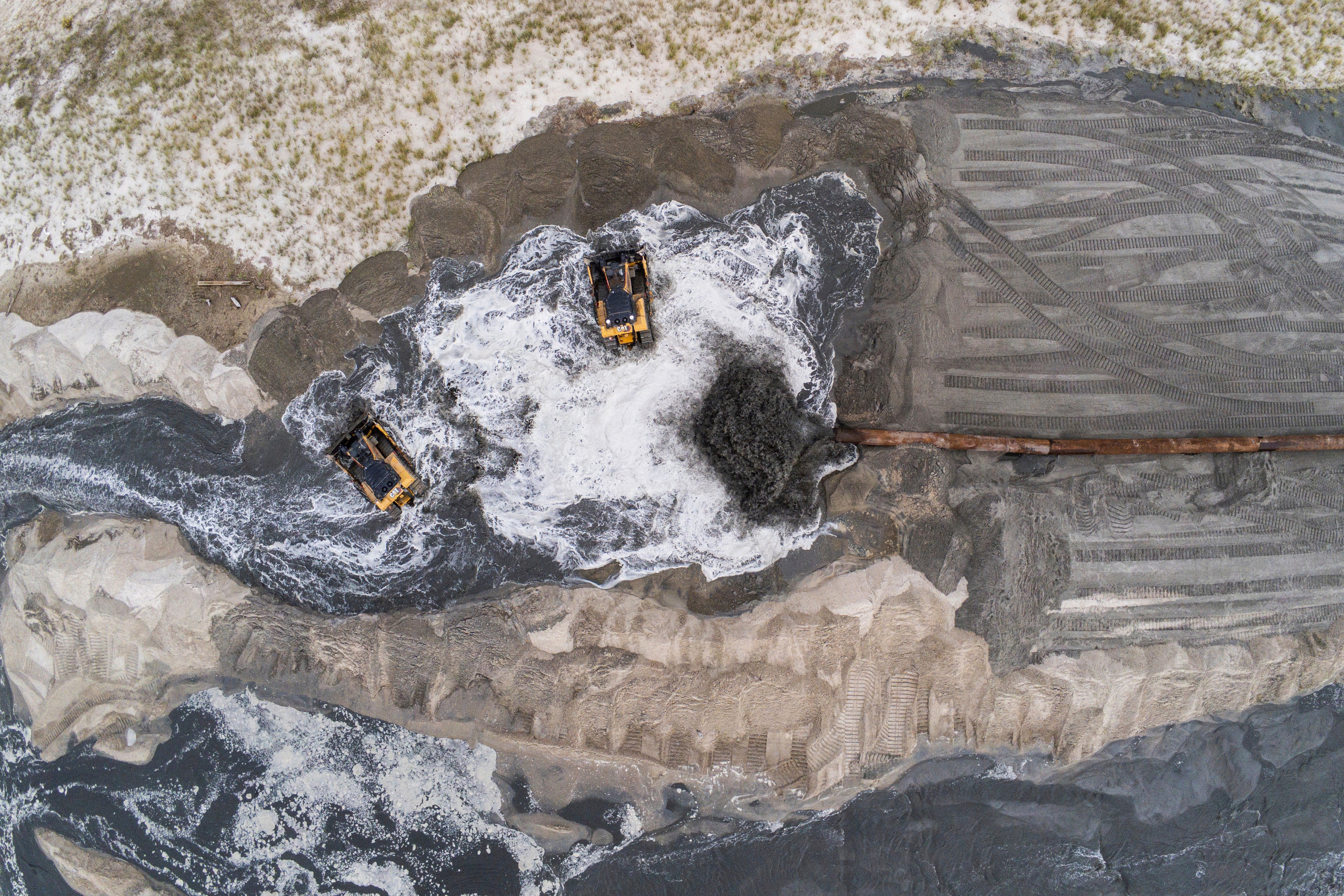 A pipe deposits sand and water from the ocean floor as sand dredging work continues in the Far Rockaway neighborhood of Queens