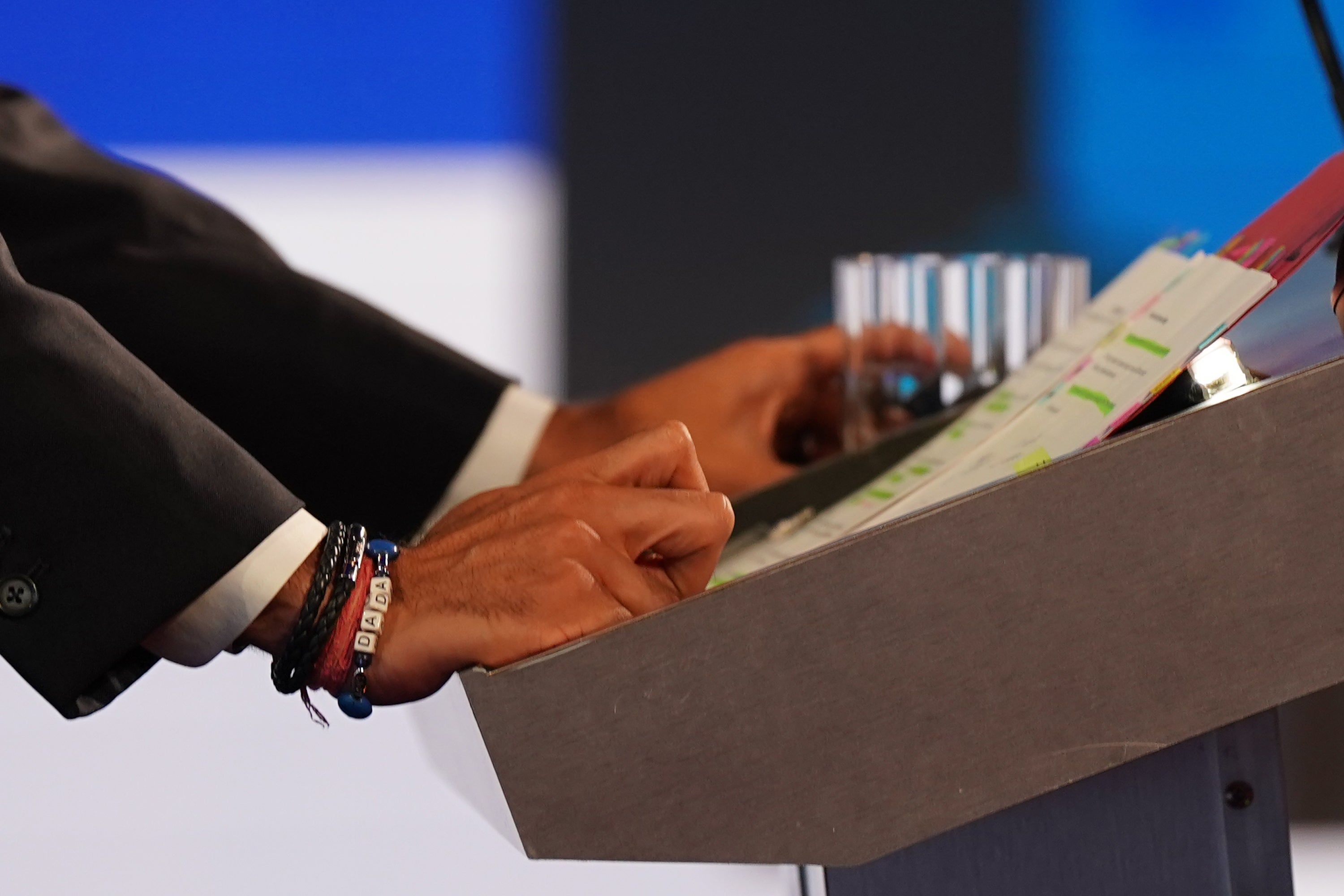 A close-up of a Dada bracelet worn by Rishi Sunak as he looks at his notes during the BBC Leadership debate at Victoria Hall on July 25, 2022