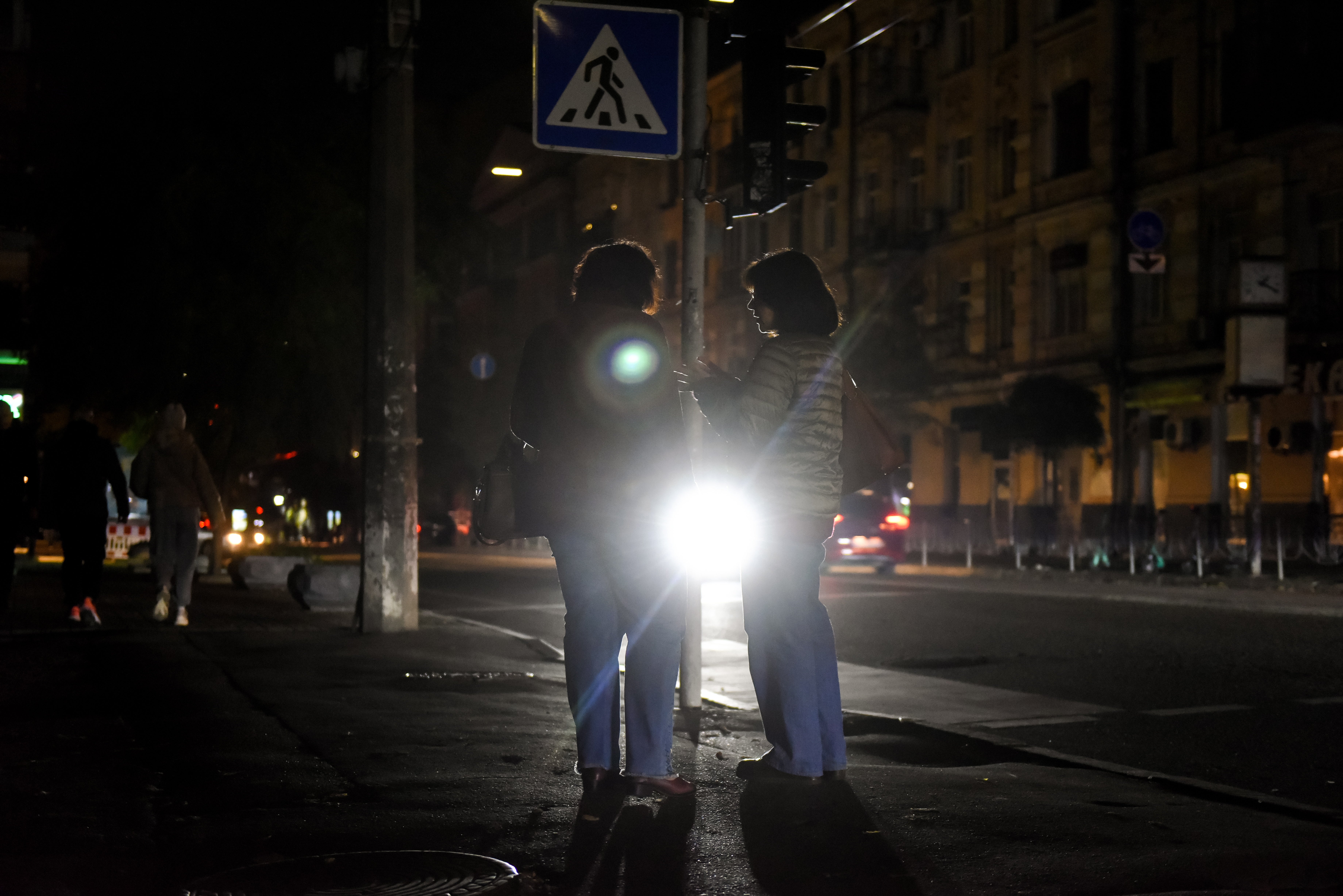 People standing as darkness descends in downtown Kyiv