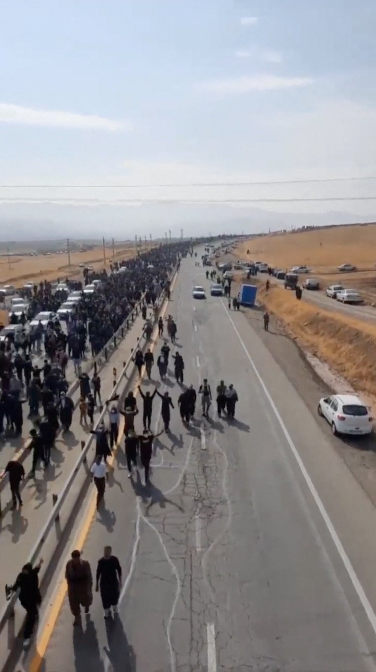 People march down the highway toward the Aychi Cemetery