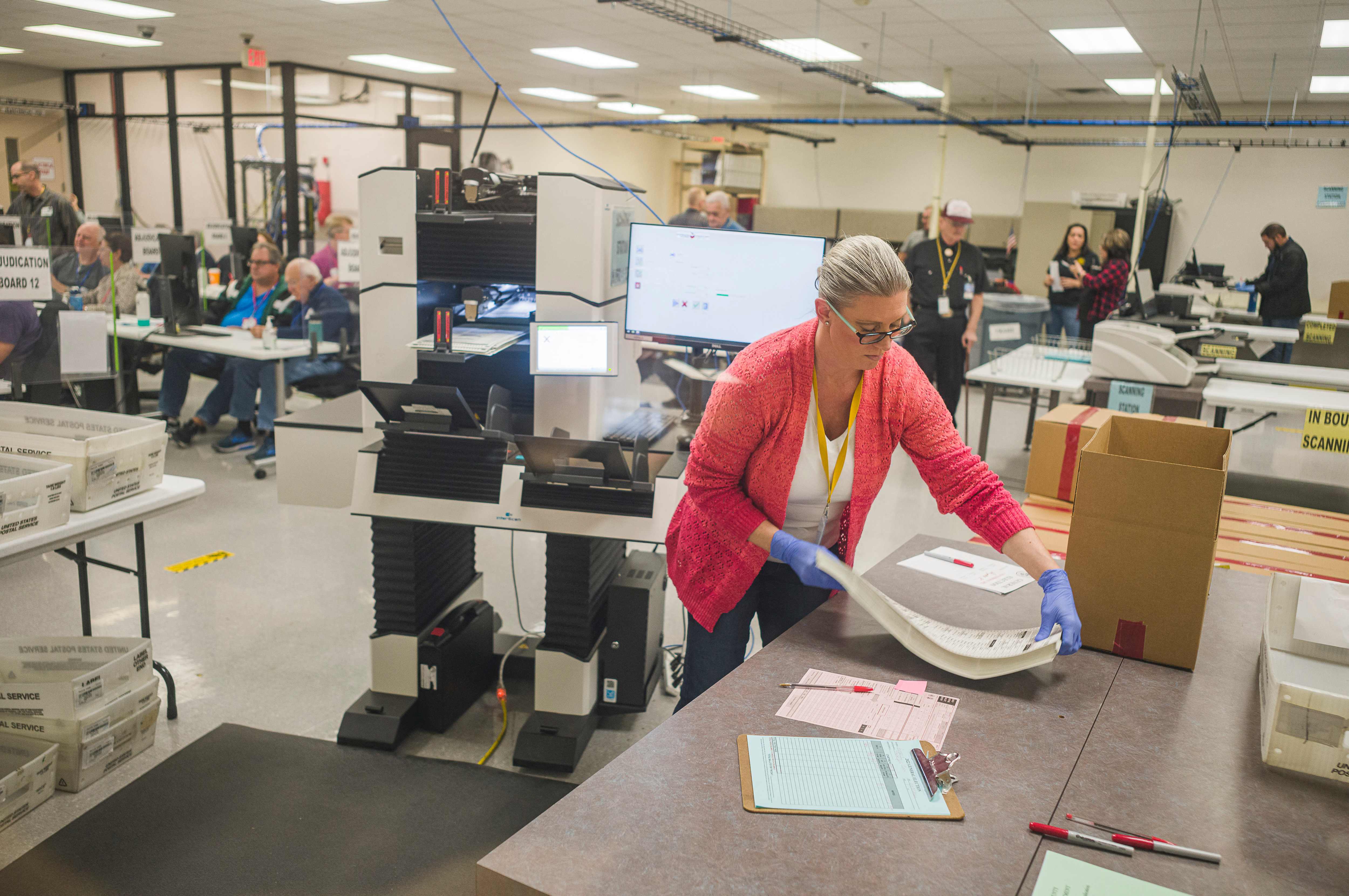 A poll worker handles ballots for midterm elections in Maricopa County, Arizona on 25 October.