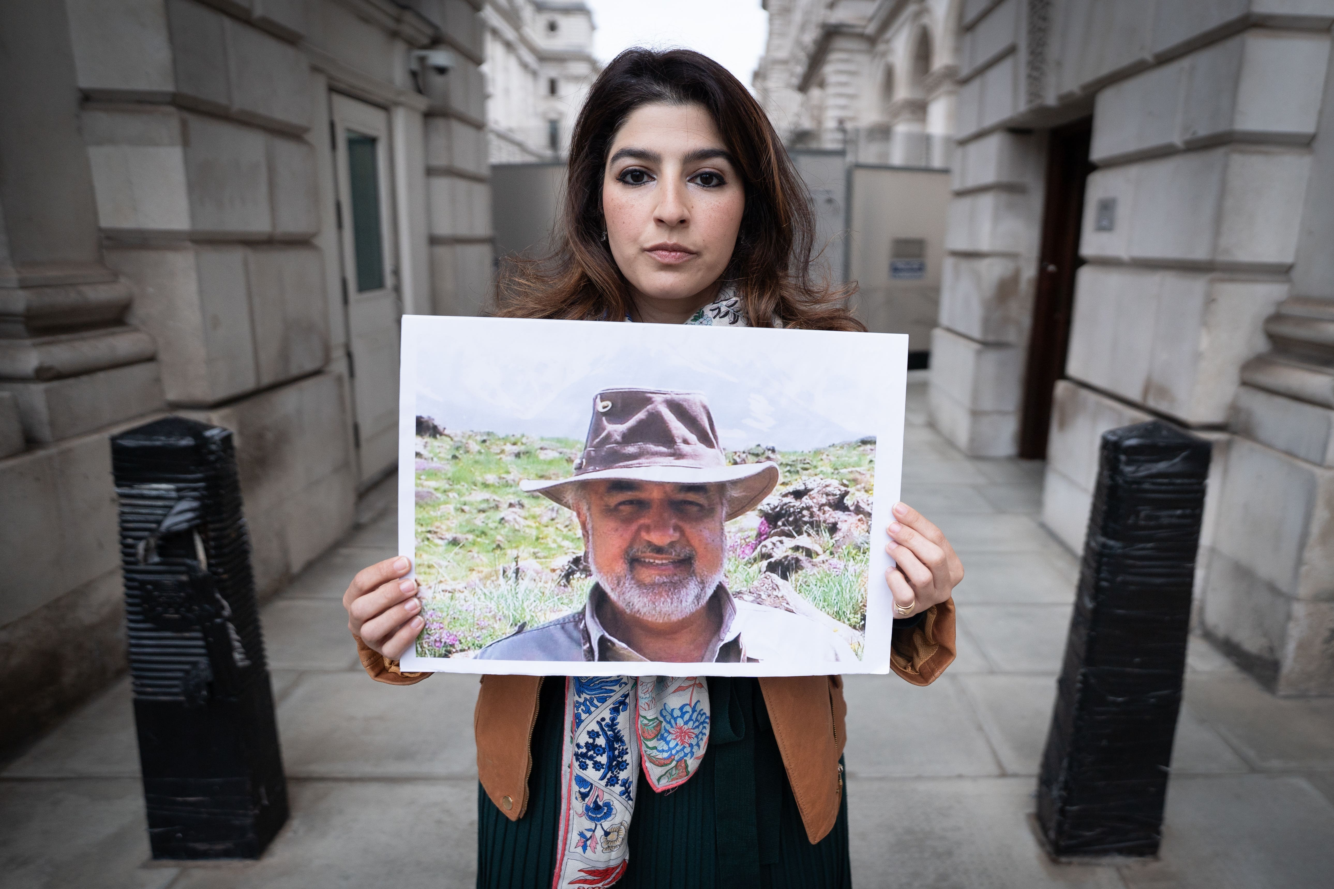 Roxanne Tahbaz holds a picture of her father, Morad, while he was in jail in Iran