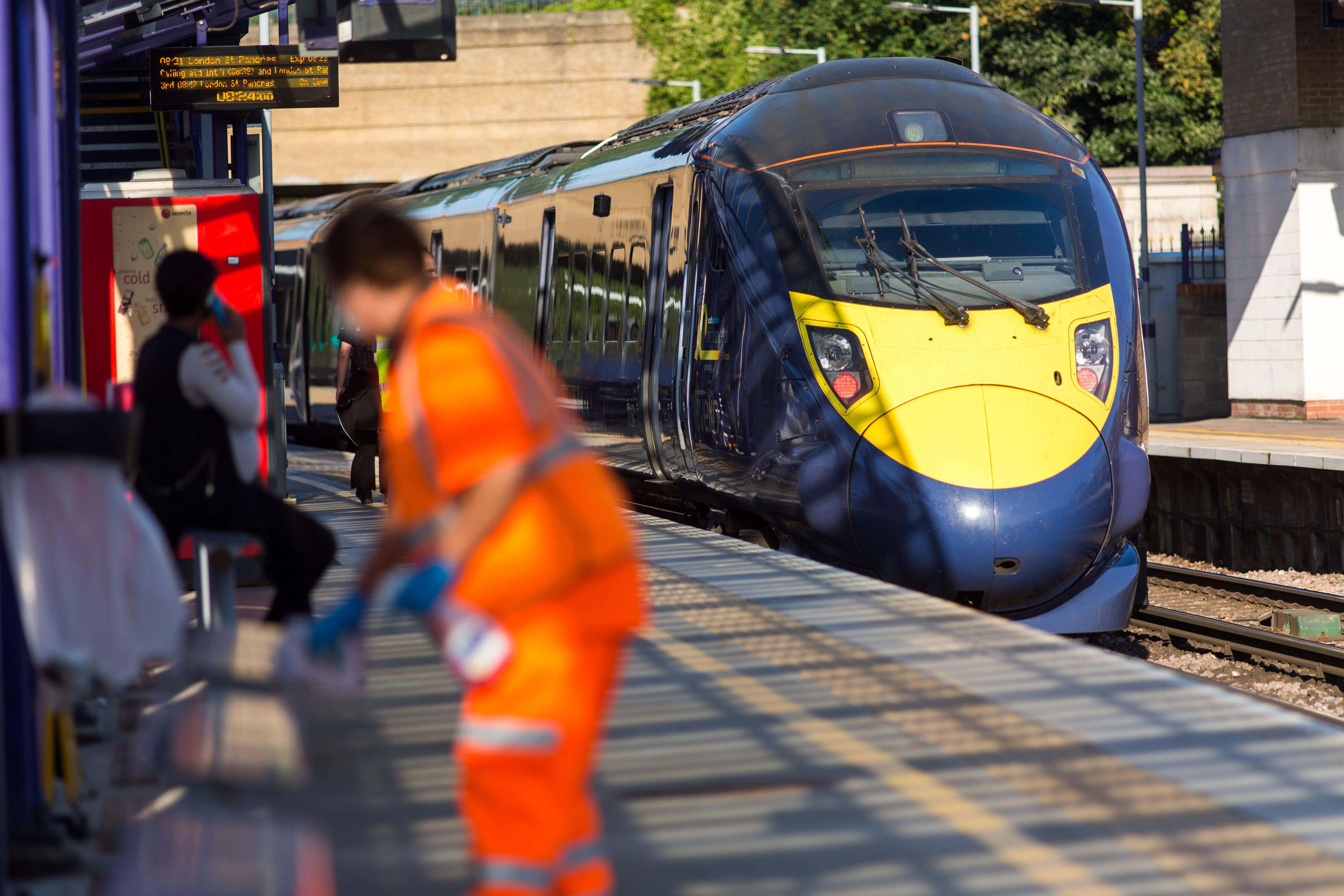 A station cleaner at work on a platform on the Southeastern railways network (Alamy/PA)