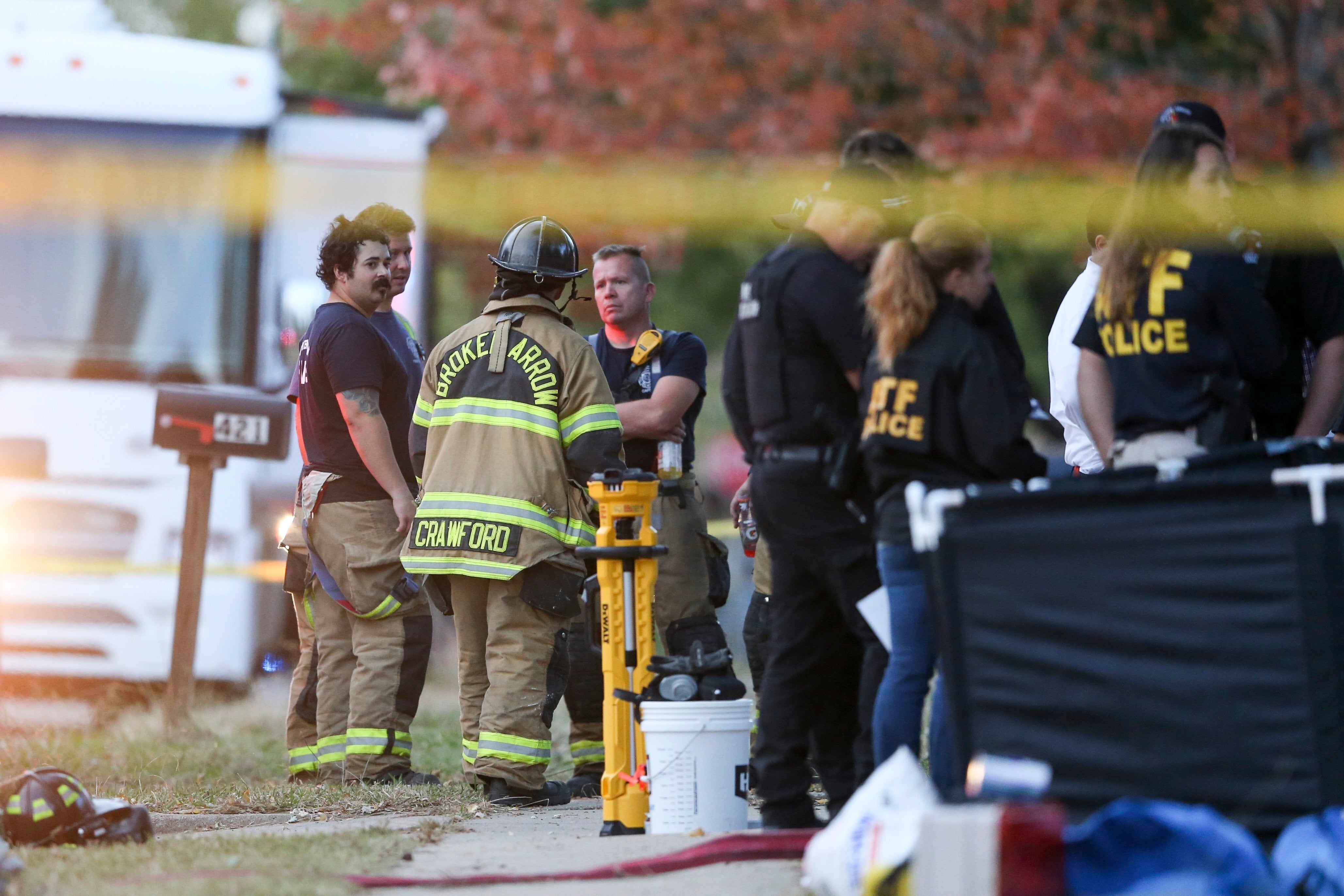 Police and firefighters investigate the scene of a house fire where eight members of the same family died in Broken Arrow, Oklahoma