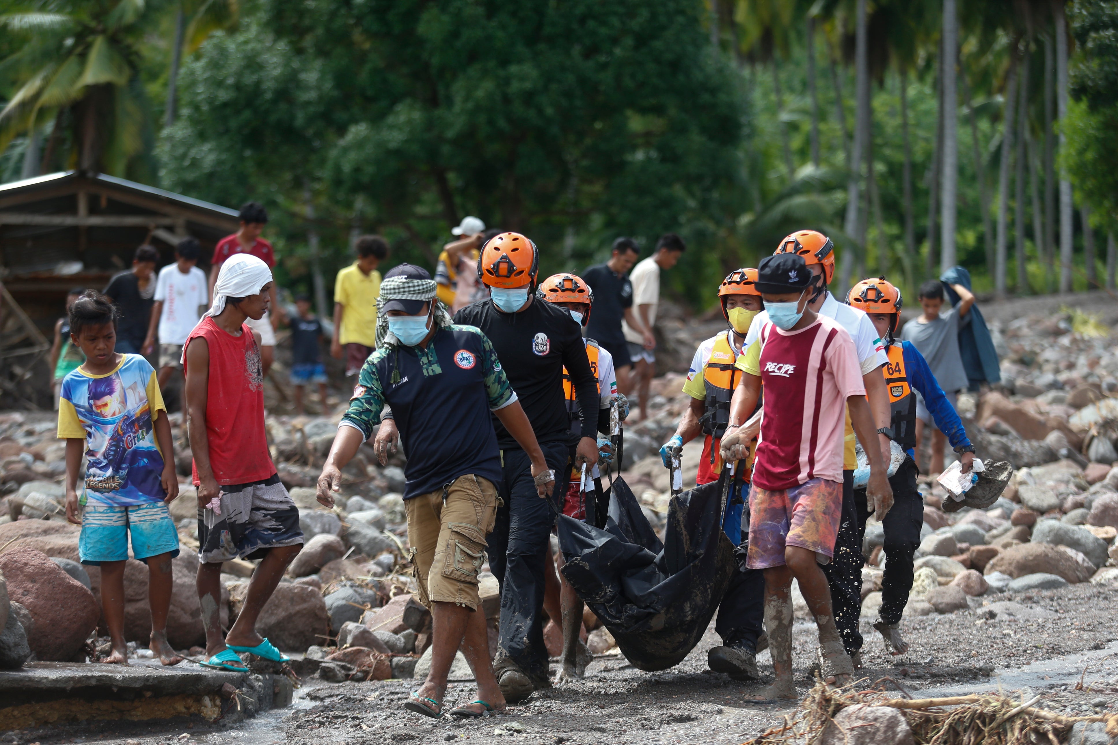 Rescuers carry a body which they retrieved after Tropical Storm Nalgae hit Maguindanao's Datu Odin Sinsuat town