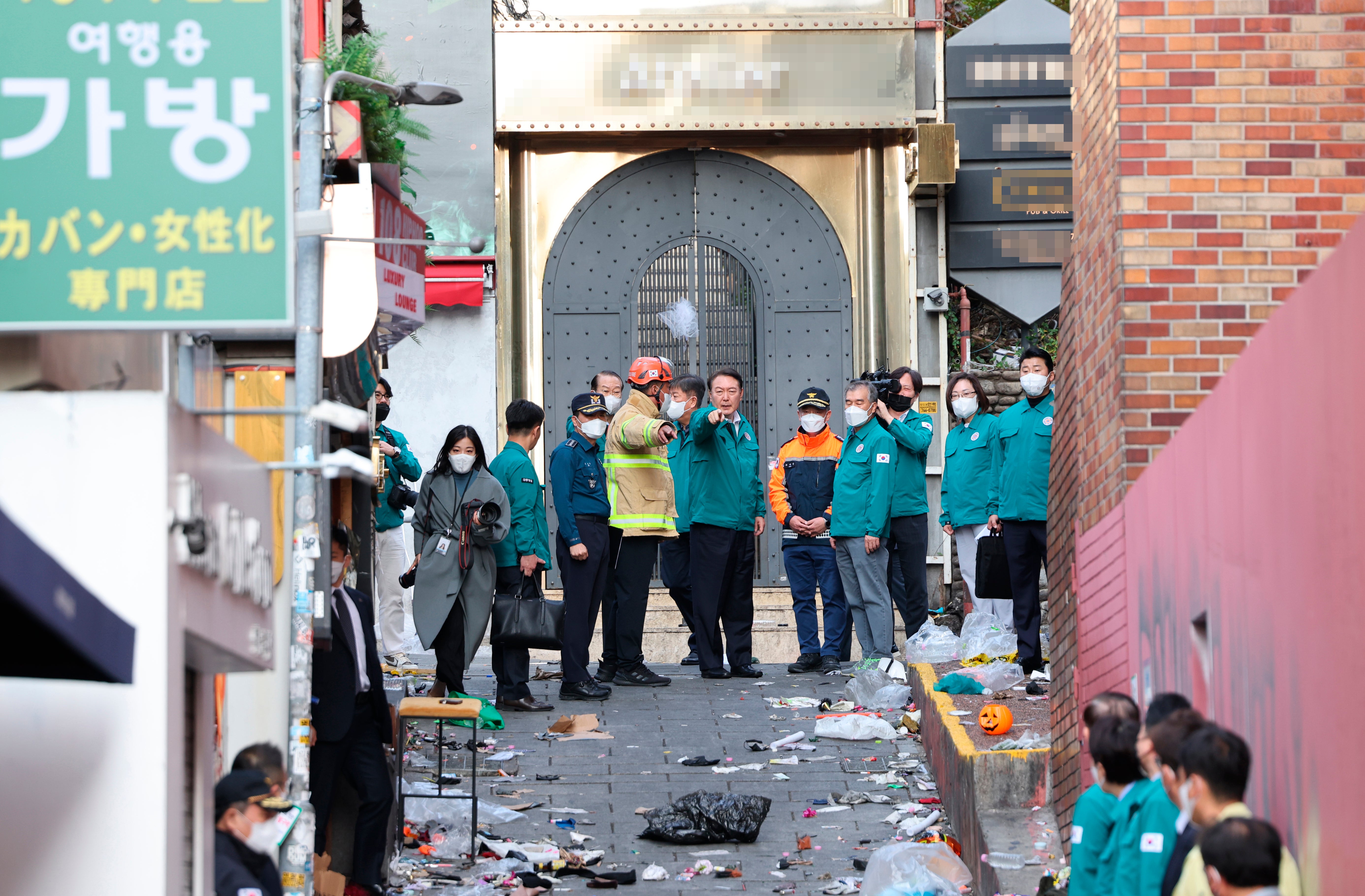 South Korean President Yoon Suk-yeol, center, visits the scene where dozens of people died