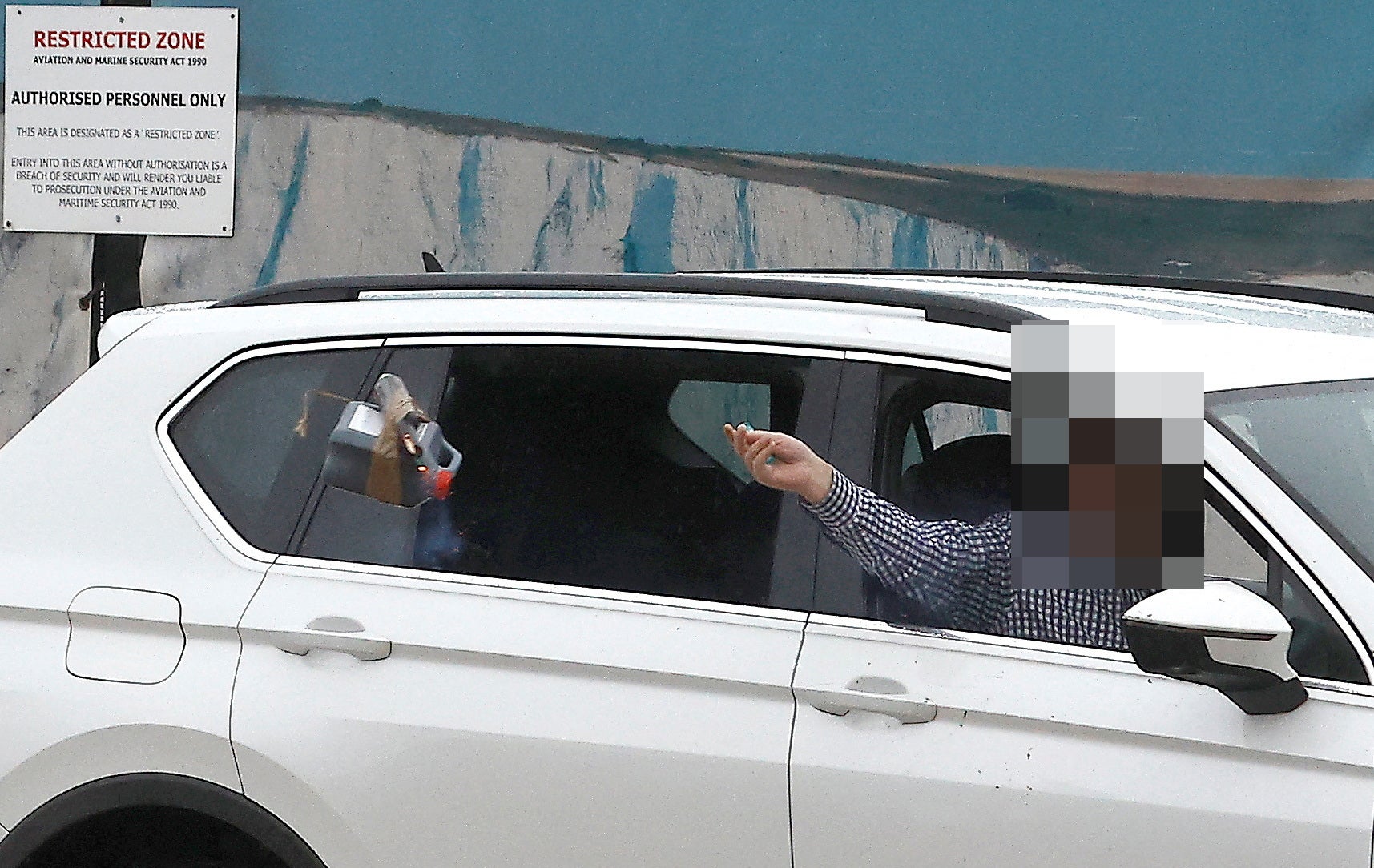 A man throws an object out of a car window next to the Border Force centre after a firebomb attack in Dover