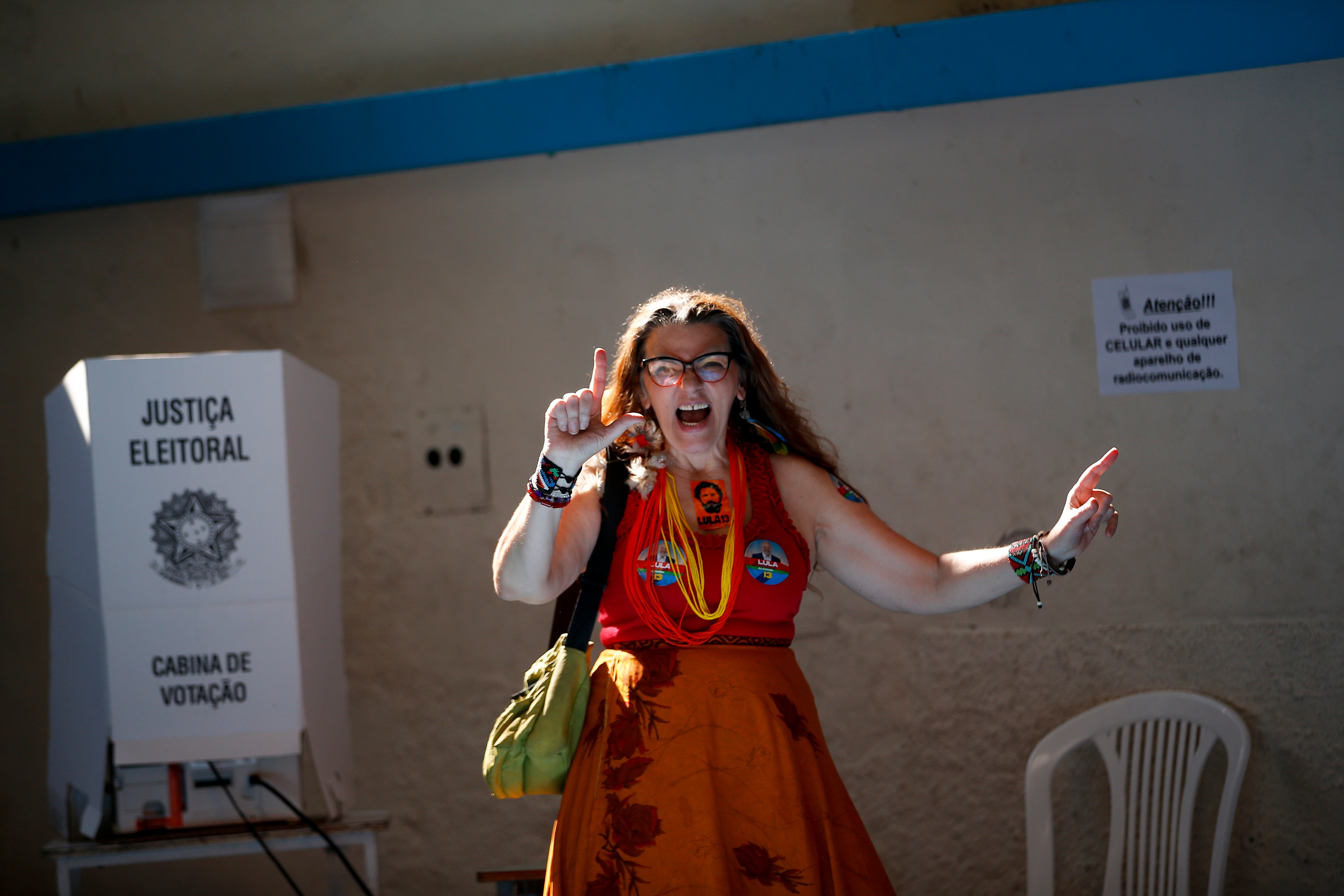 A woman signs an “L” in support of Lula after voting during the presidential run-off election in Rio de Janeiro