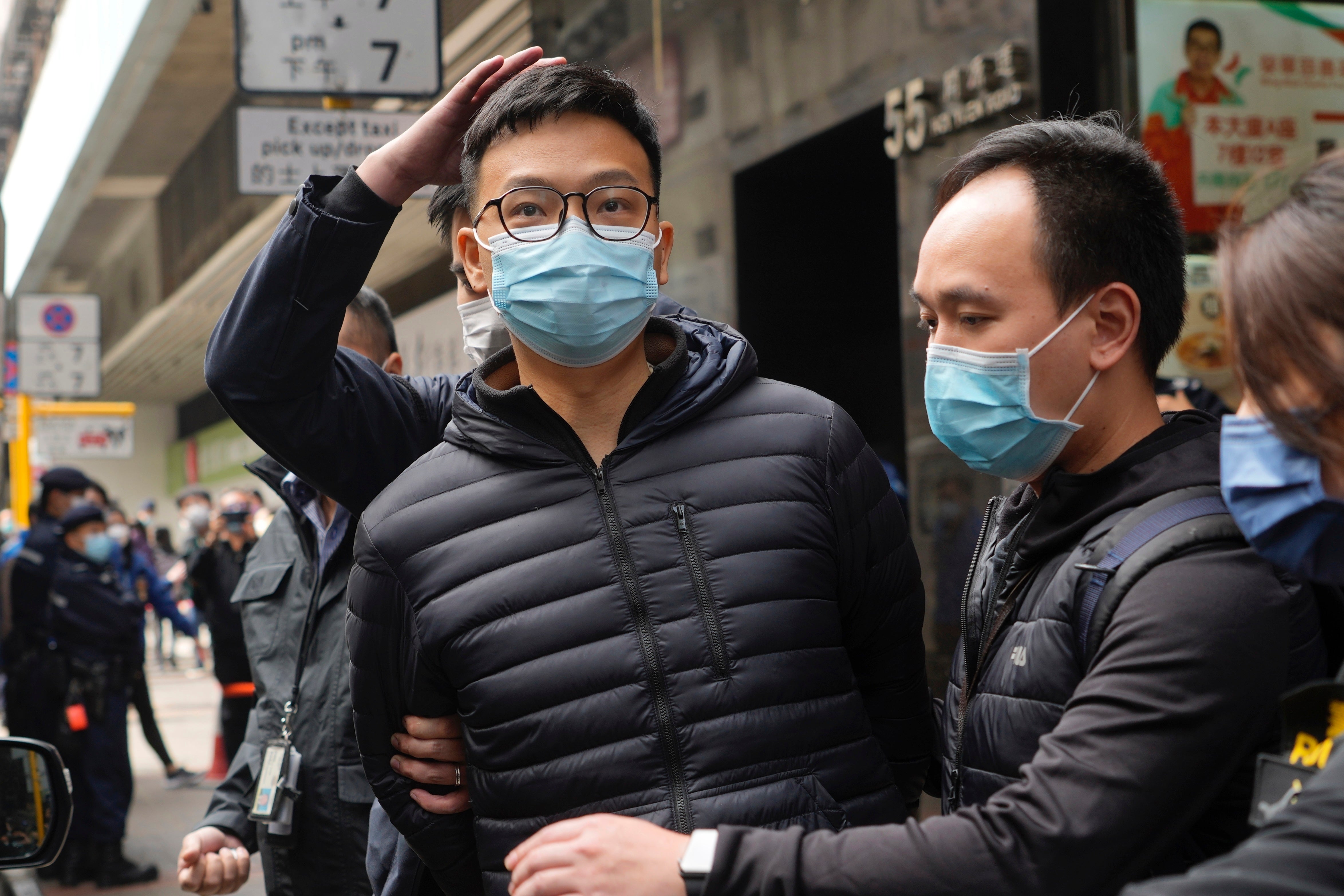 Patrick Lam, centre, escorted by police in 2022