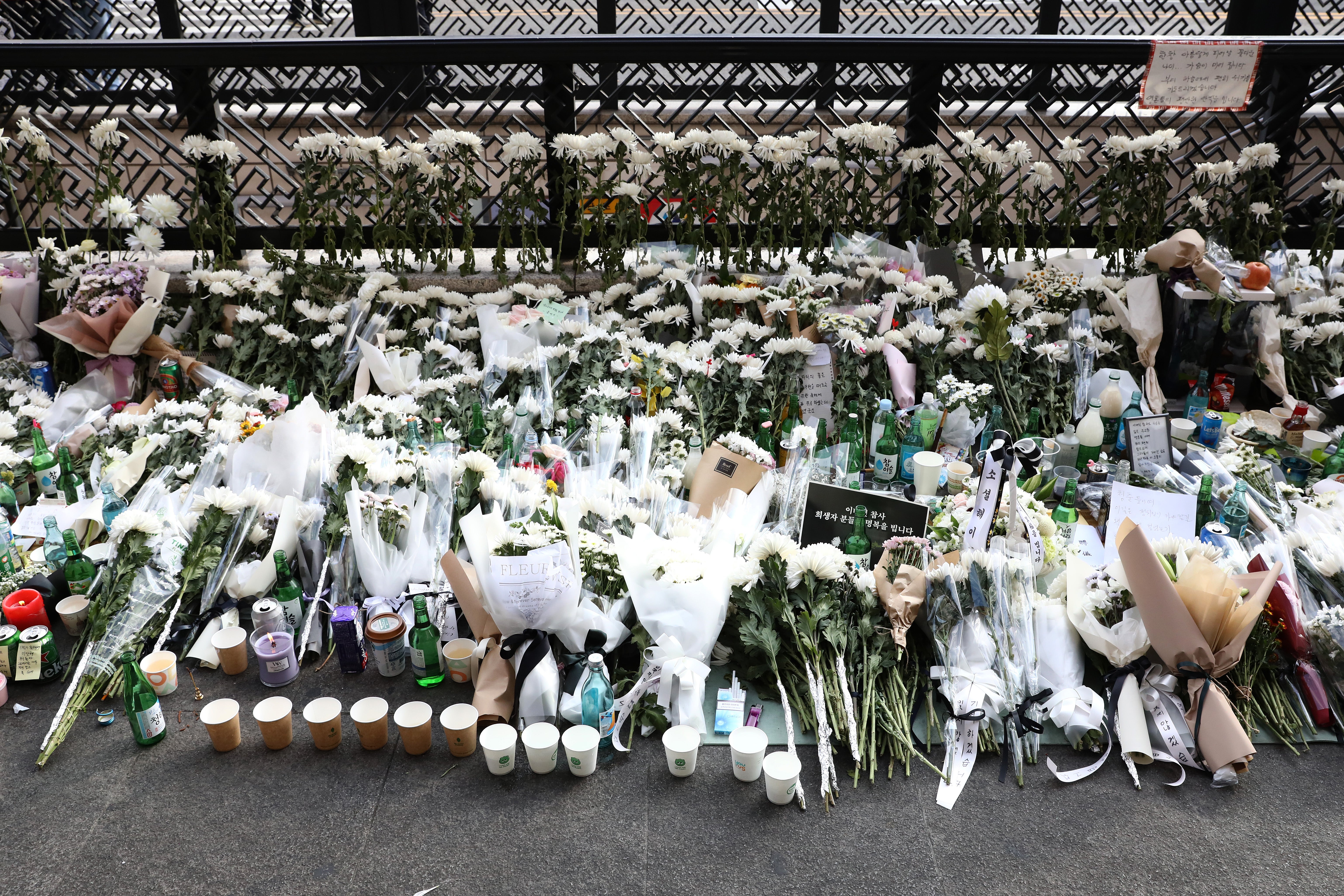 Flowers are laid for tribute the victims of the Halloween celebration stampede on the street near the scene