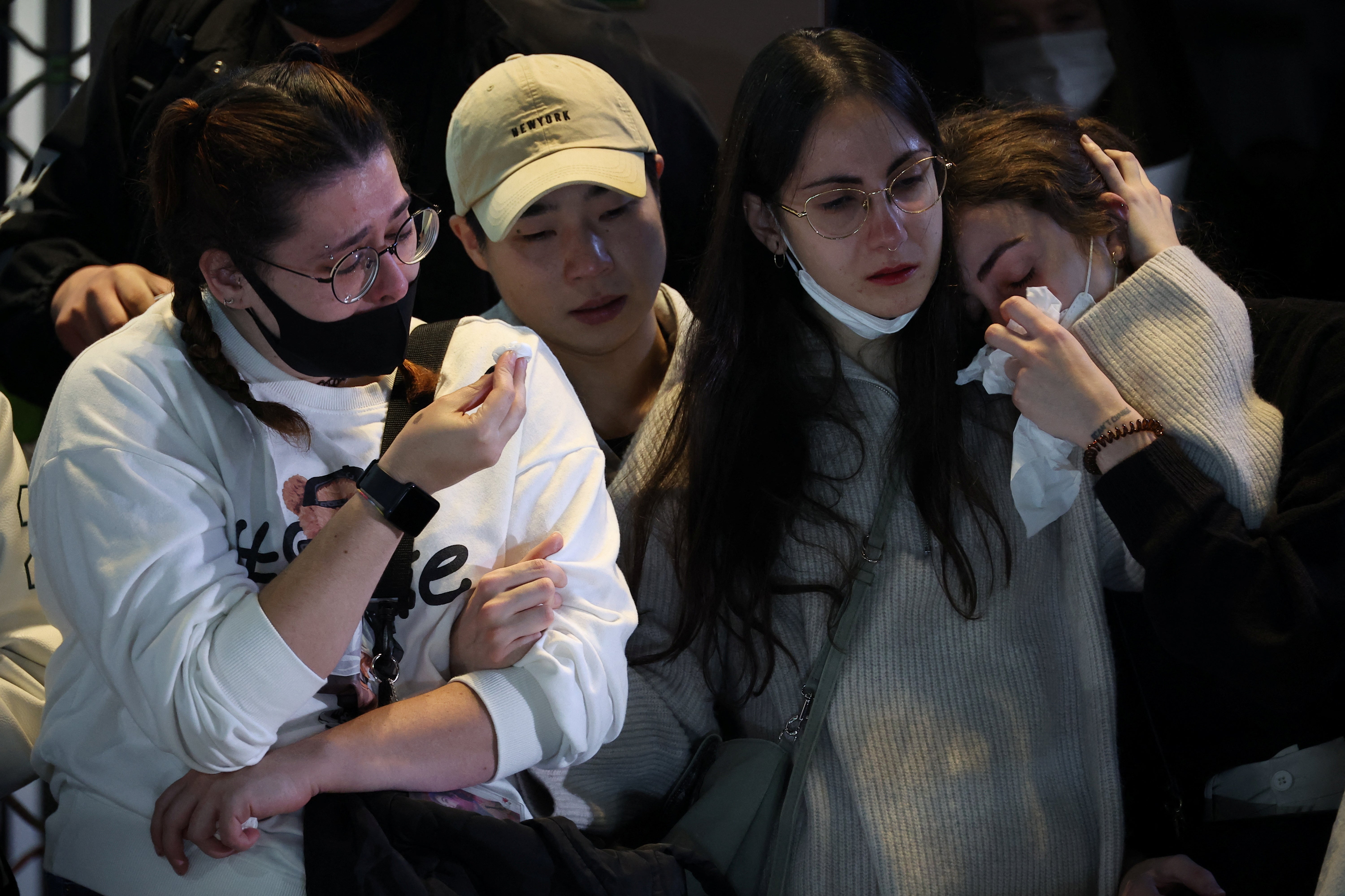 People react near the scene of a crowd crush that happened during Halloween festivities, in Seoul, South Korea