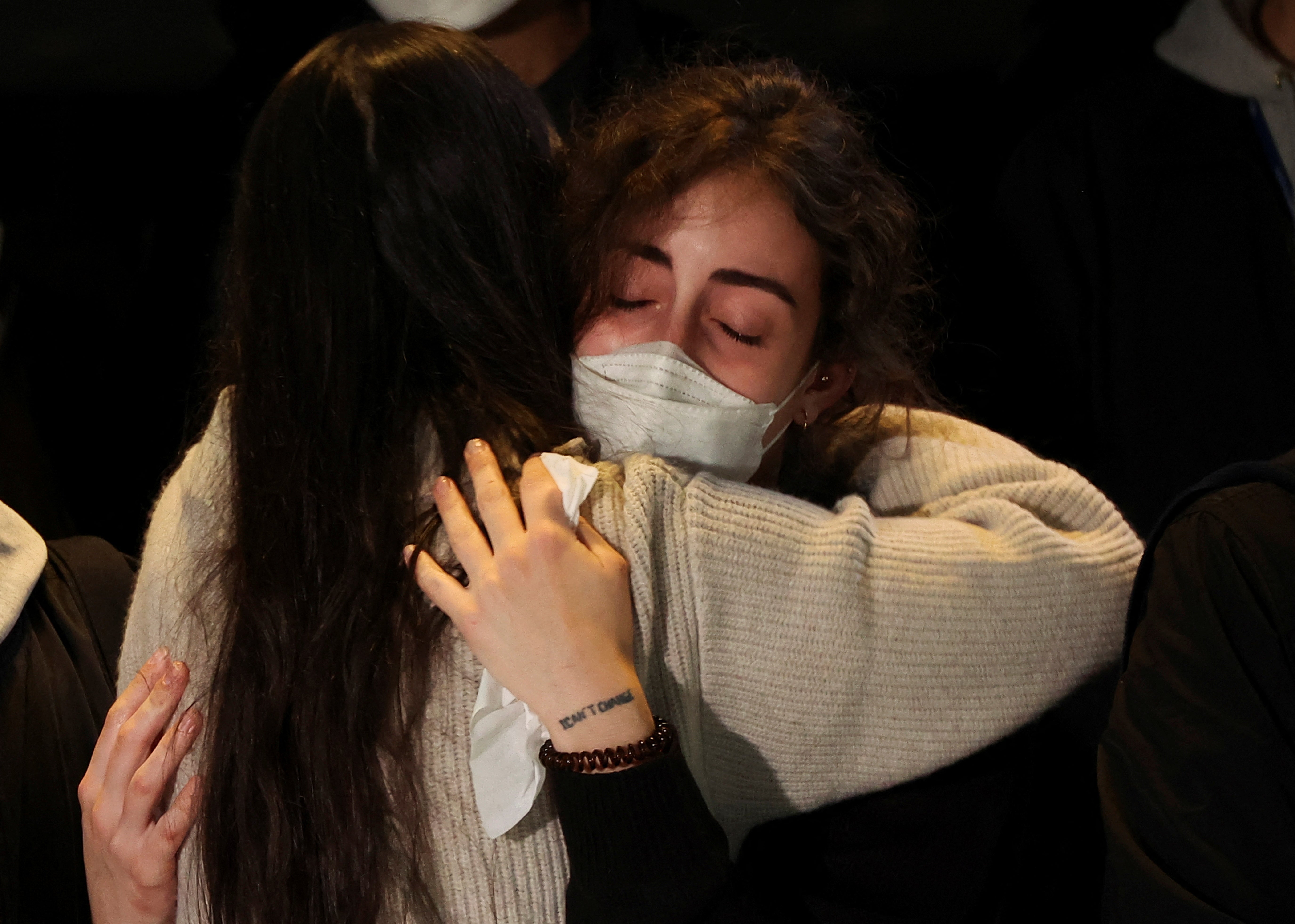 People comfort each other as they grieve those lost in the stampede