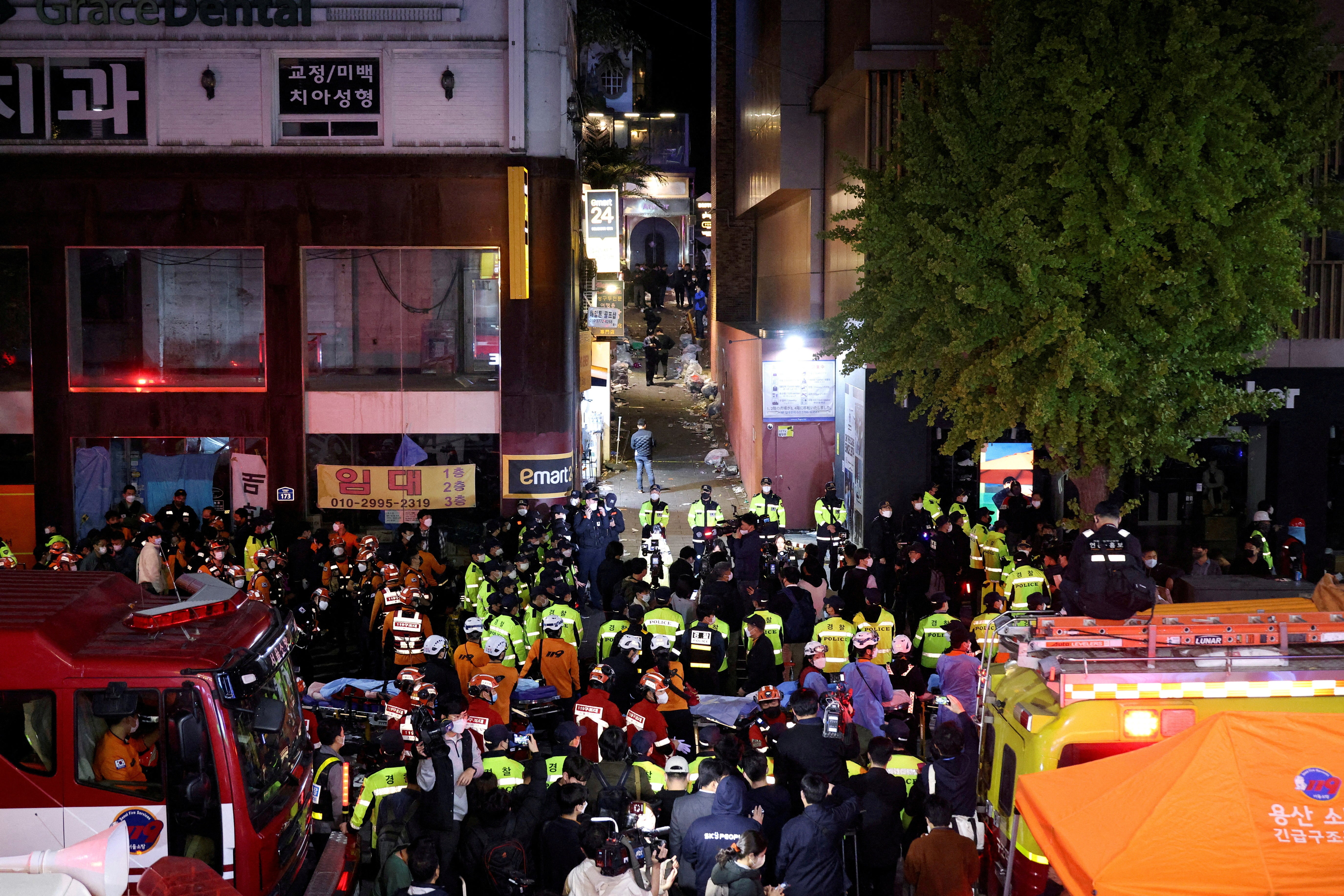 Rescue teams and firefighters work at the scene where people were killed and injured in a crush during Halloween festivities