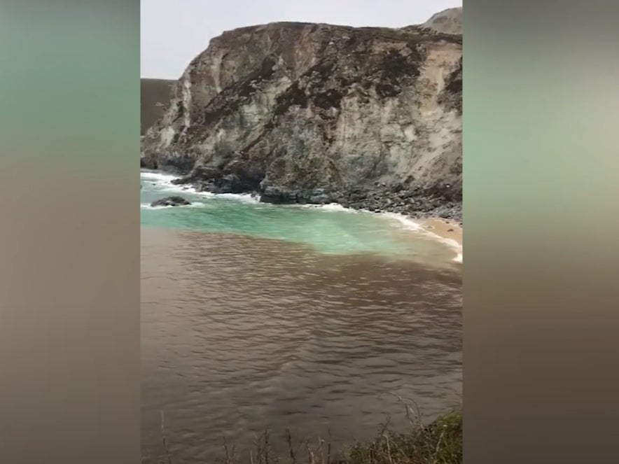 Murky brown sea surrounds a Cornwall beach after a sewage spill