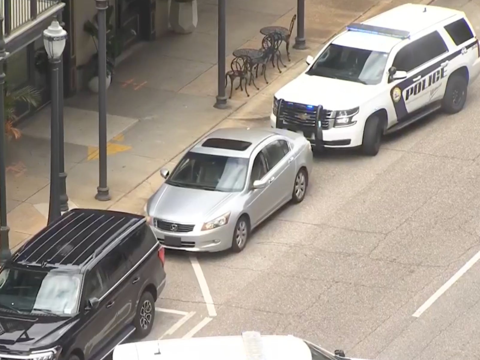 An armed man sits in a silver vehicle in downtown Mobile, Alabama