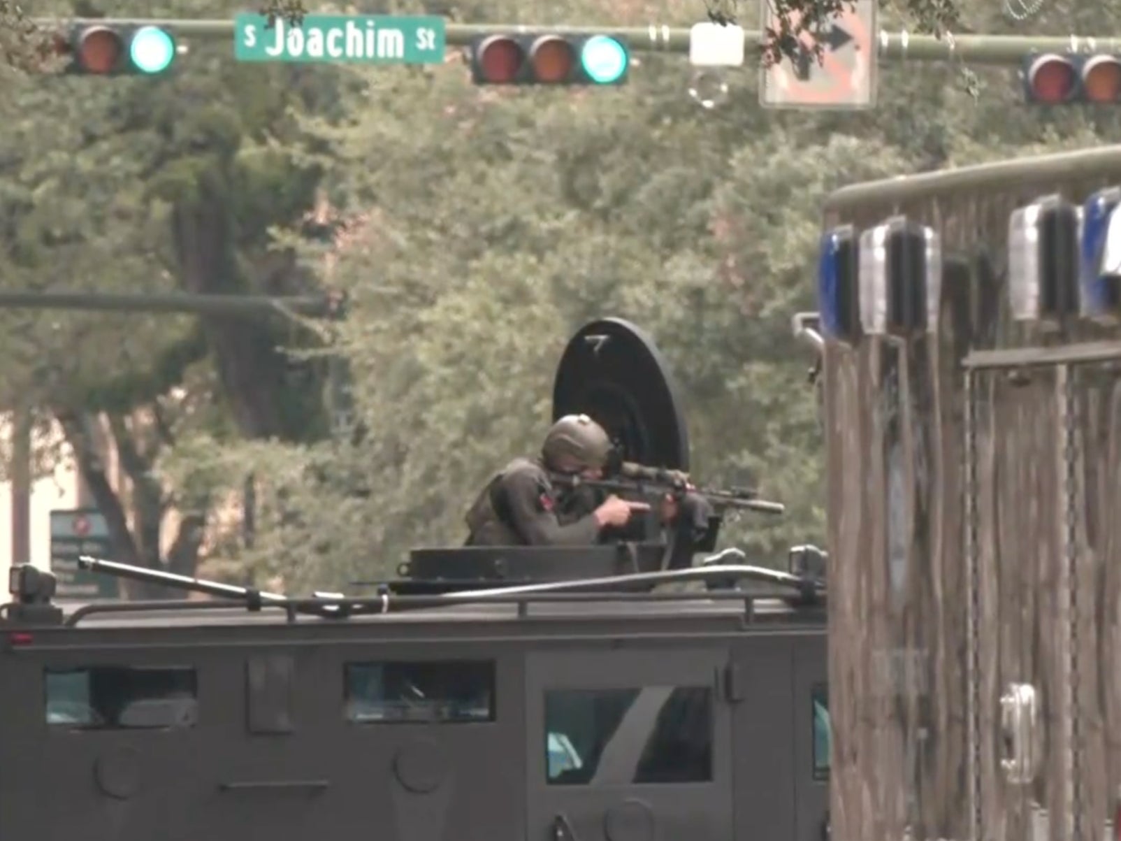 A law enforcement officer aims a weapon in downtown Mobile, Alabama