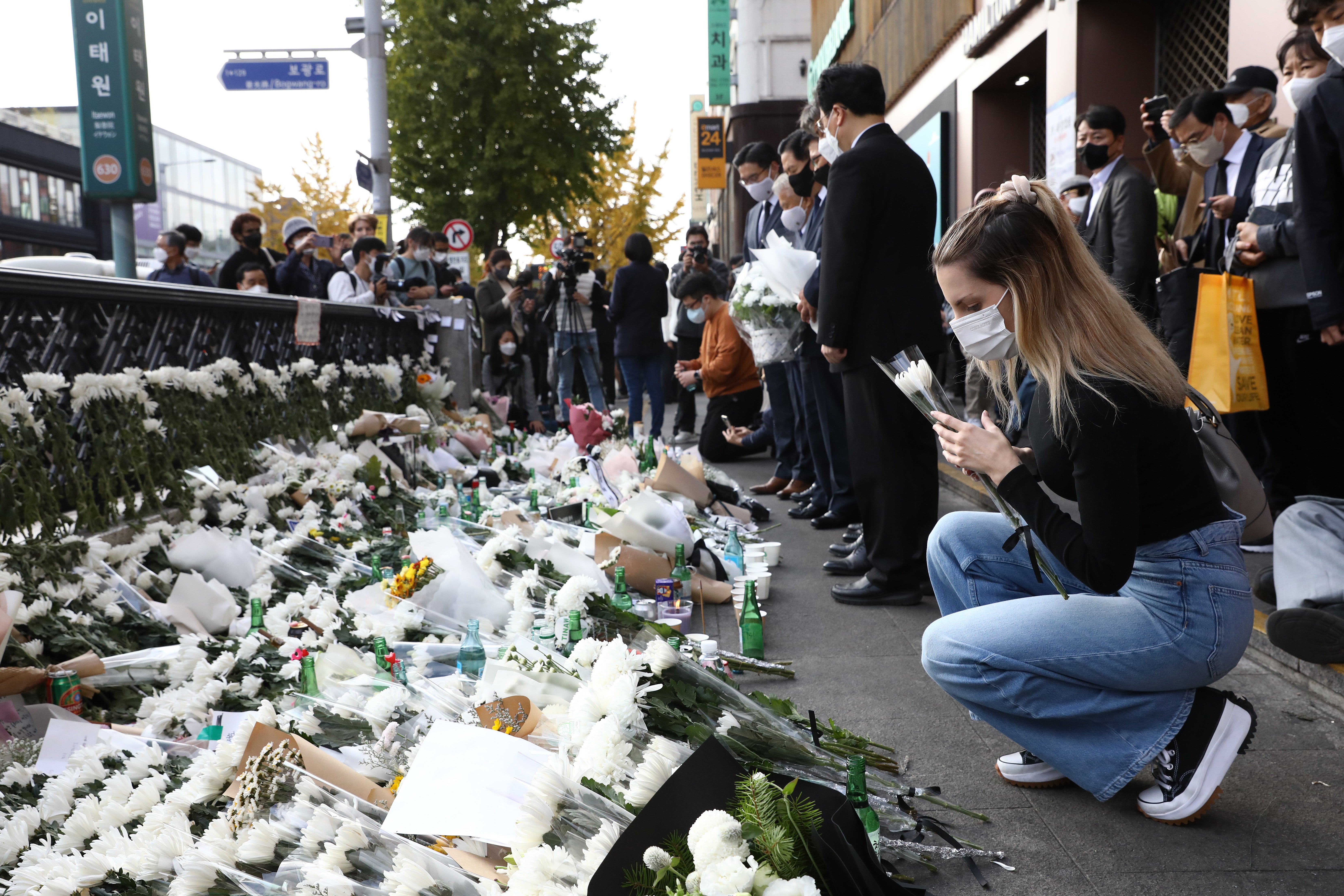 A woman pays tribute for the victims of the Halloween celebration stampede, on the street near the scene on 31 October 2022 in Seoul, South Korea