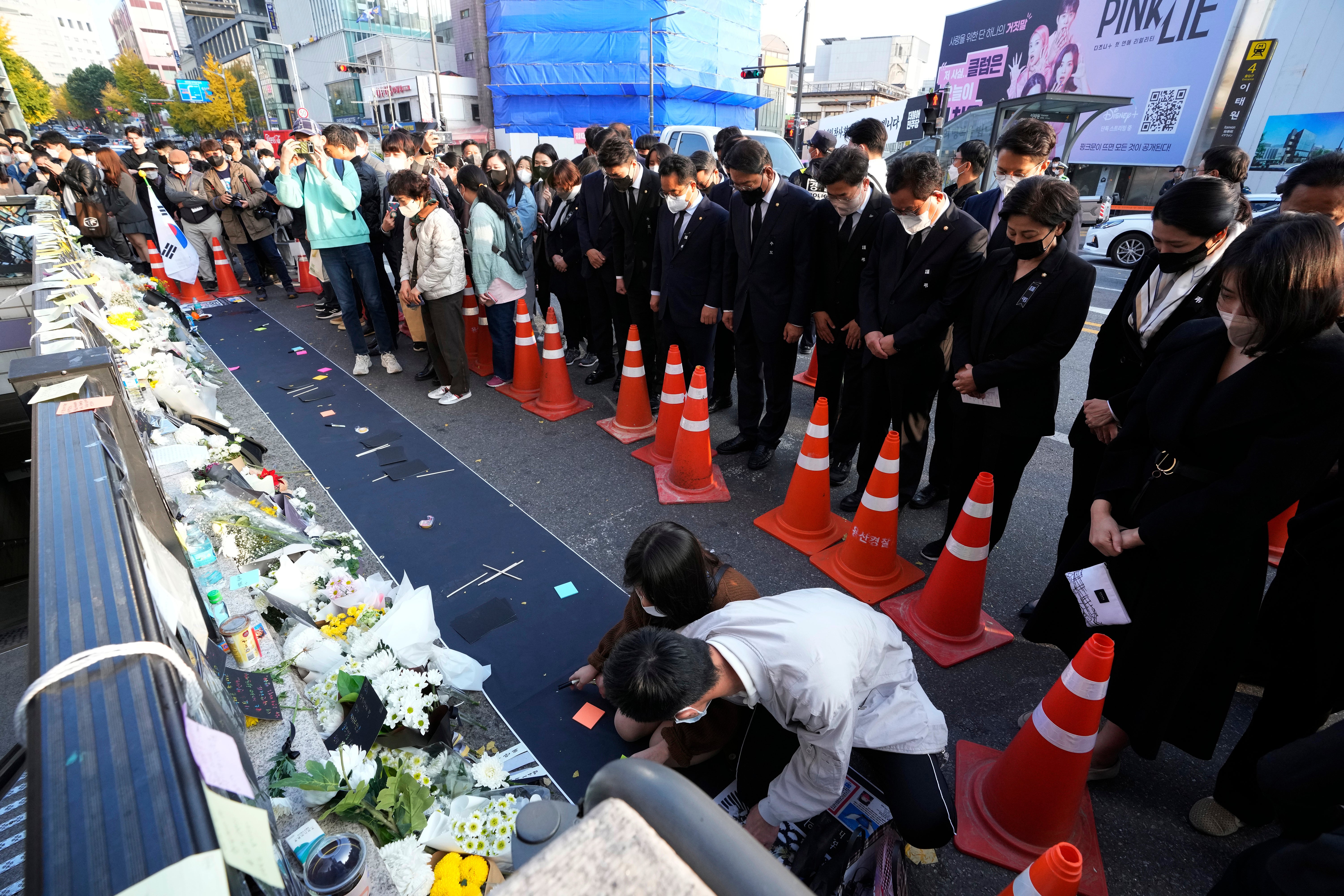 People pay tribute to victims of a deadly accident following Saturday night's Halloween festivities