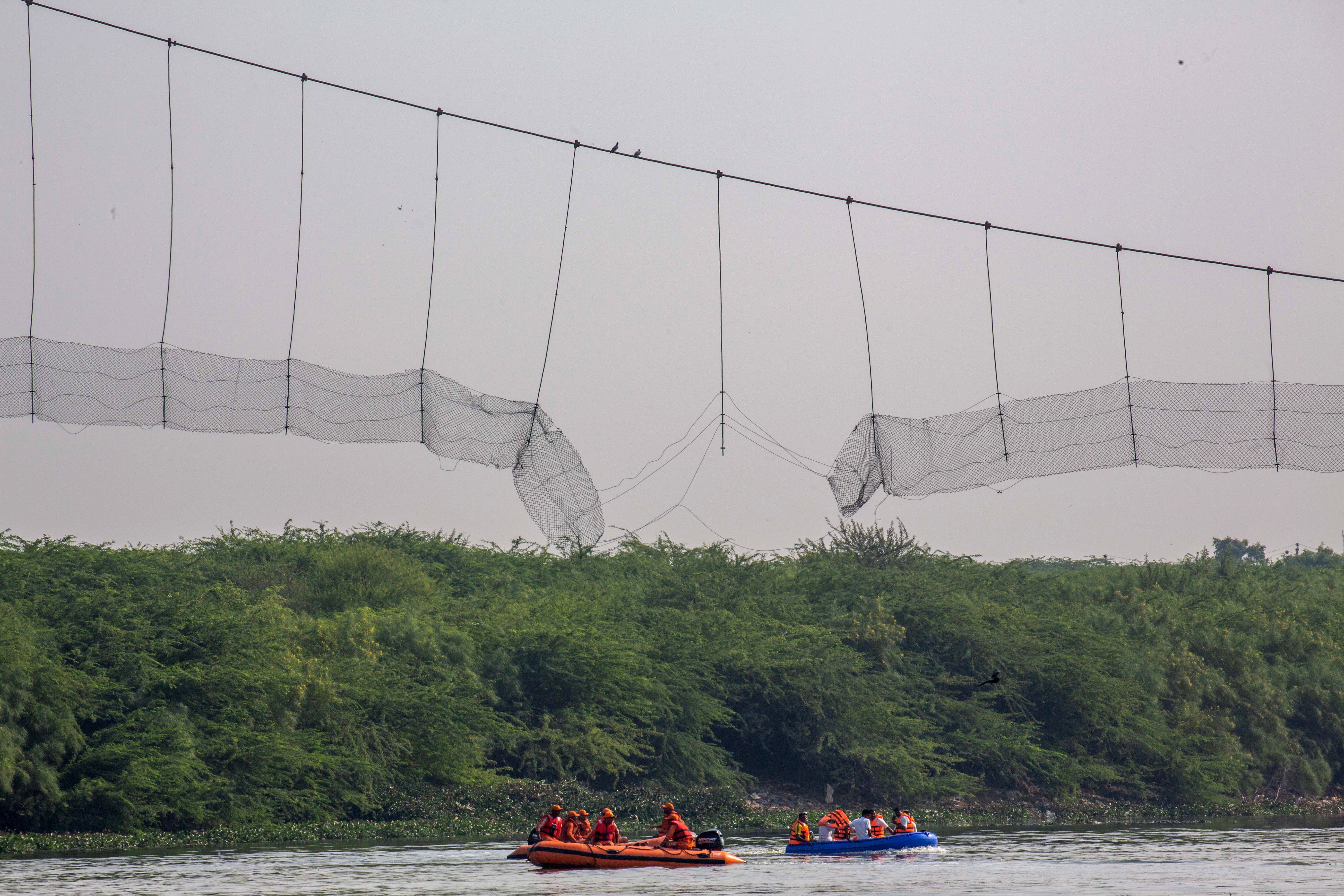 The collapsed Jhulto Pul, a pedestrian suspension bridge, during a rescue operation in Morbi