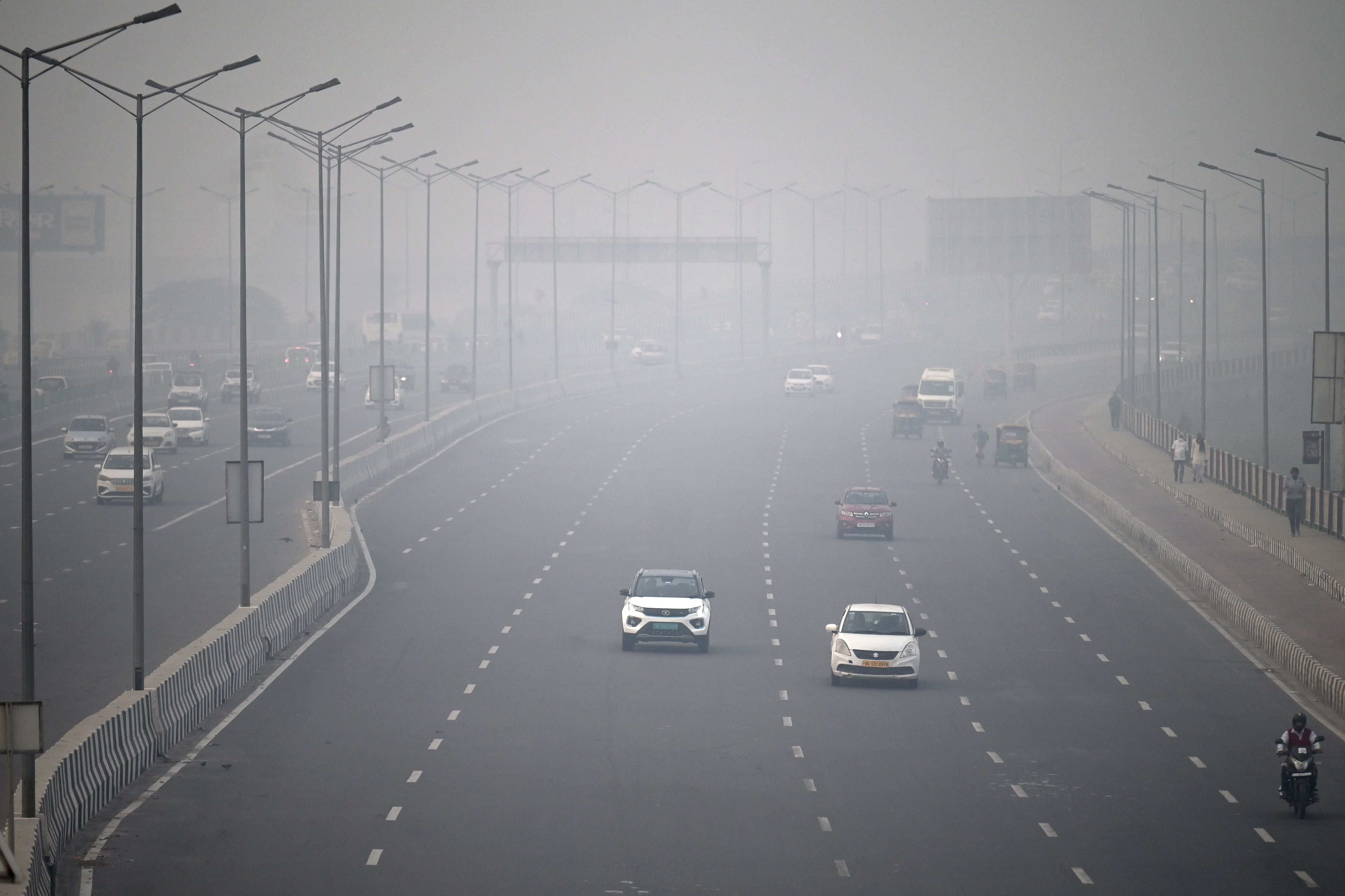 People commute along a road amid smoggy conditions in New Delhi