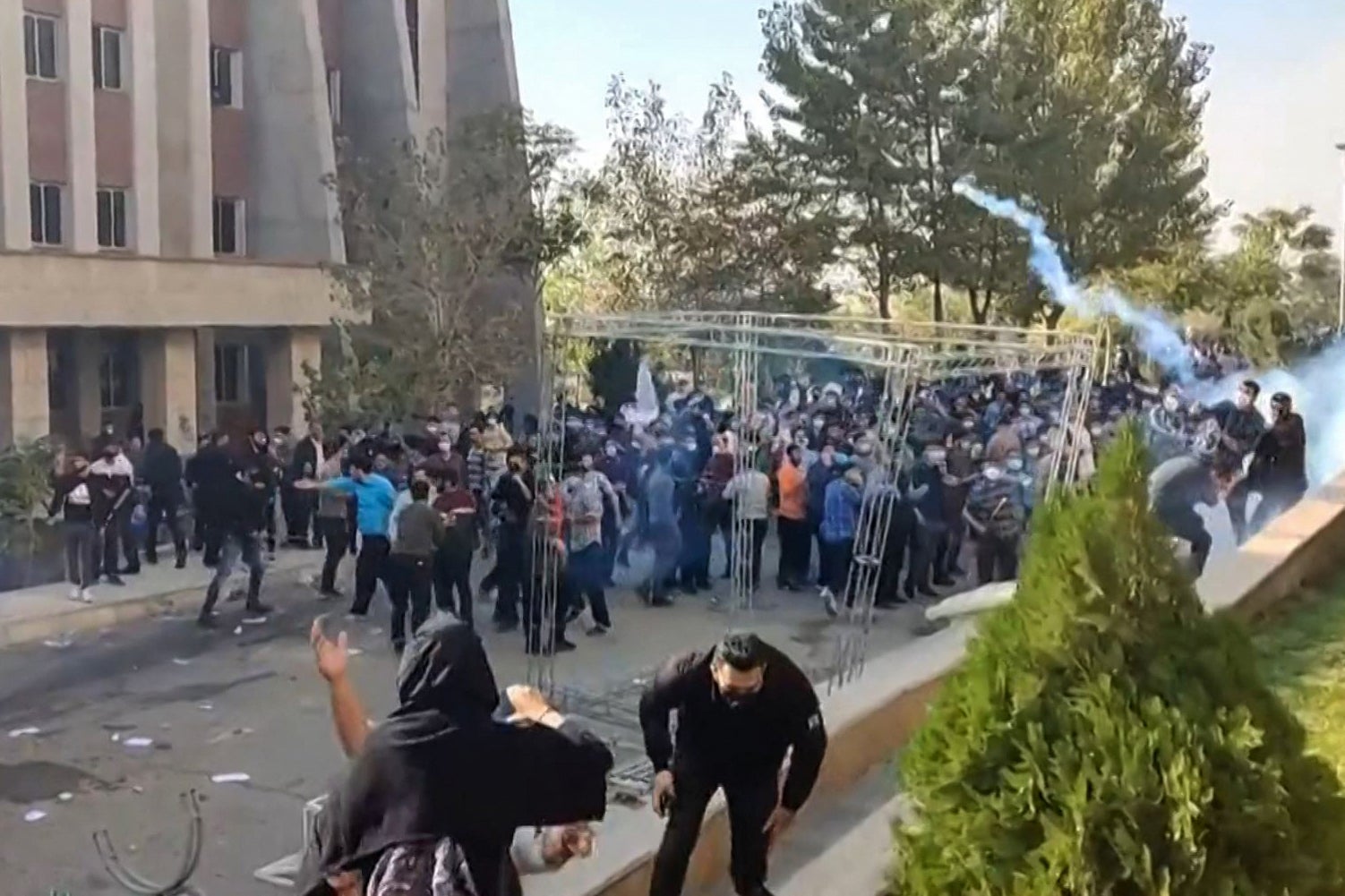 This image grab from a UGC video posted on 30 October reportedly shows protesters avoiding projectiles during clashes at Iran’s University of North Tehran