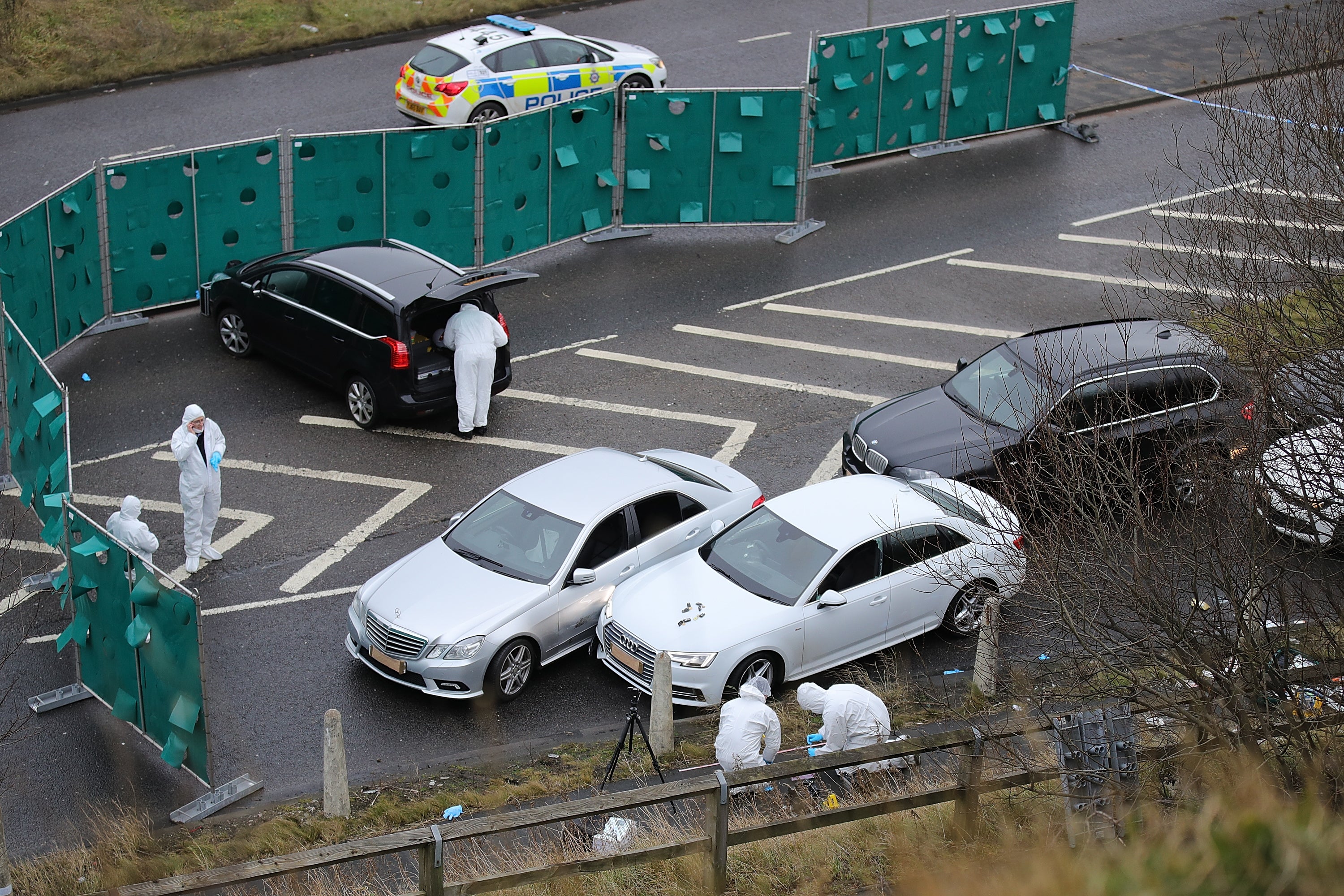 Police forensics officers at the scene of the shooting examine the silver Audi which Yaqib rode in