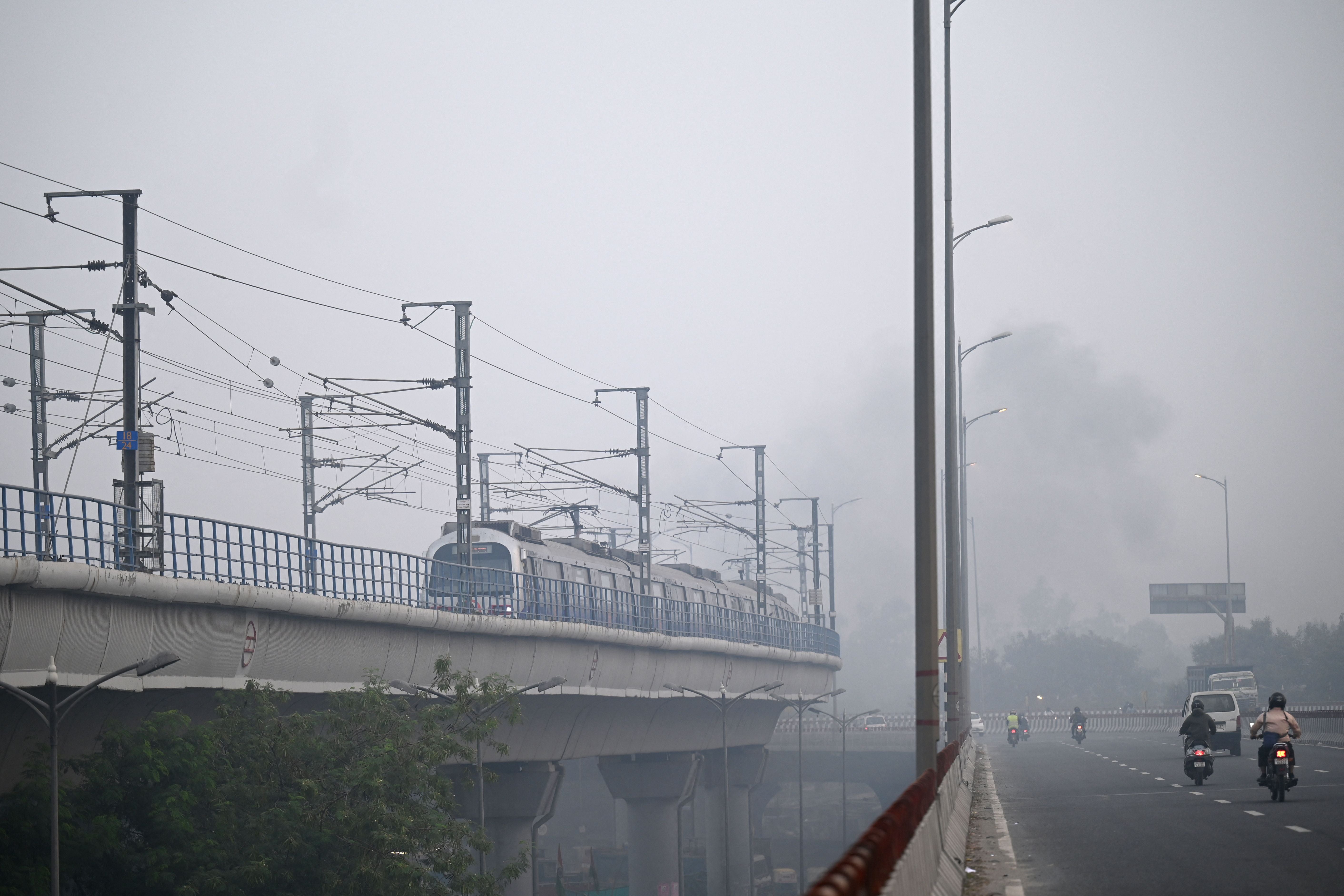 People commute along a road amid smoggy conditions in New Delhi