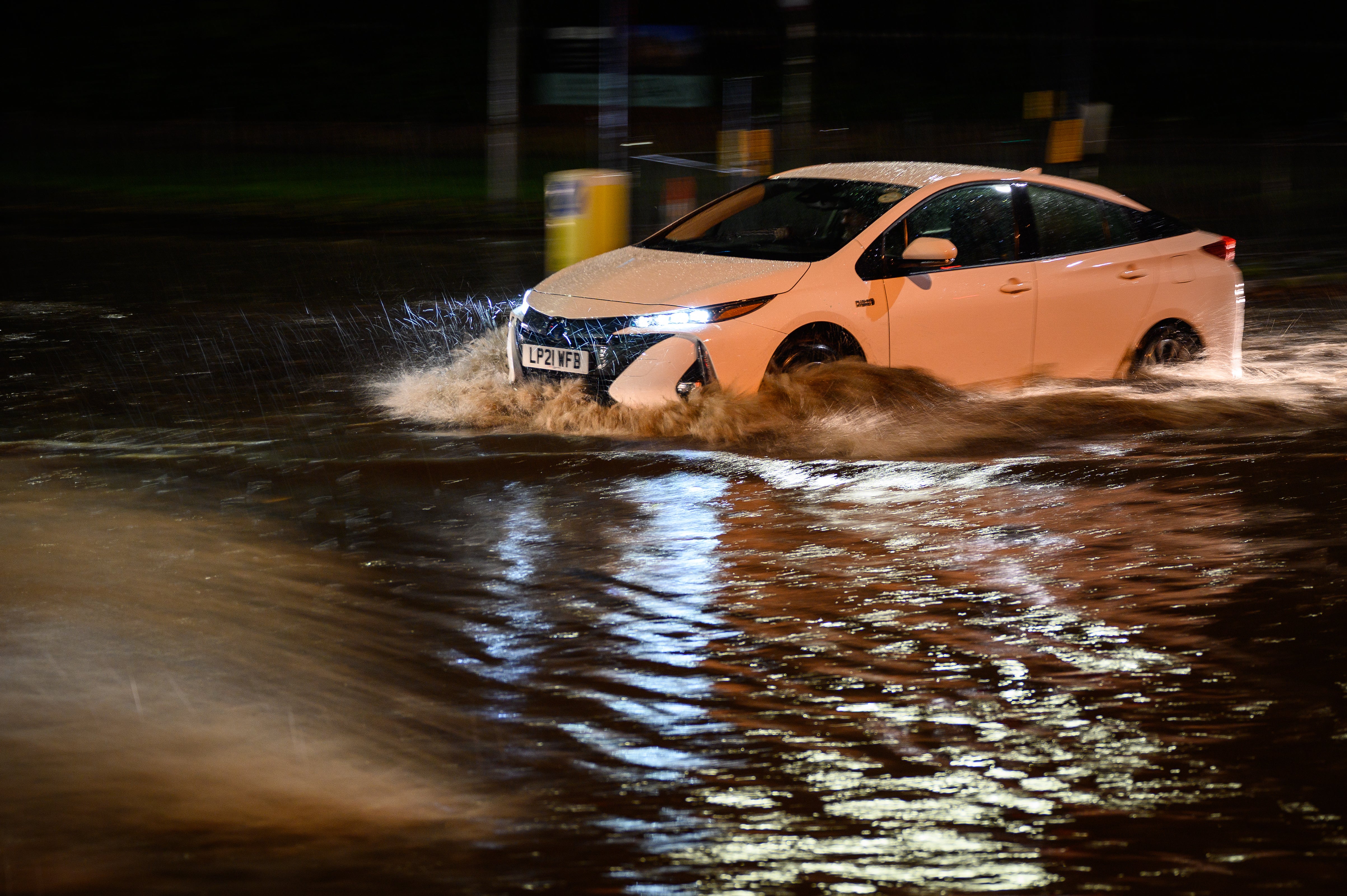 A car navigates a flooded road in London