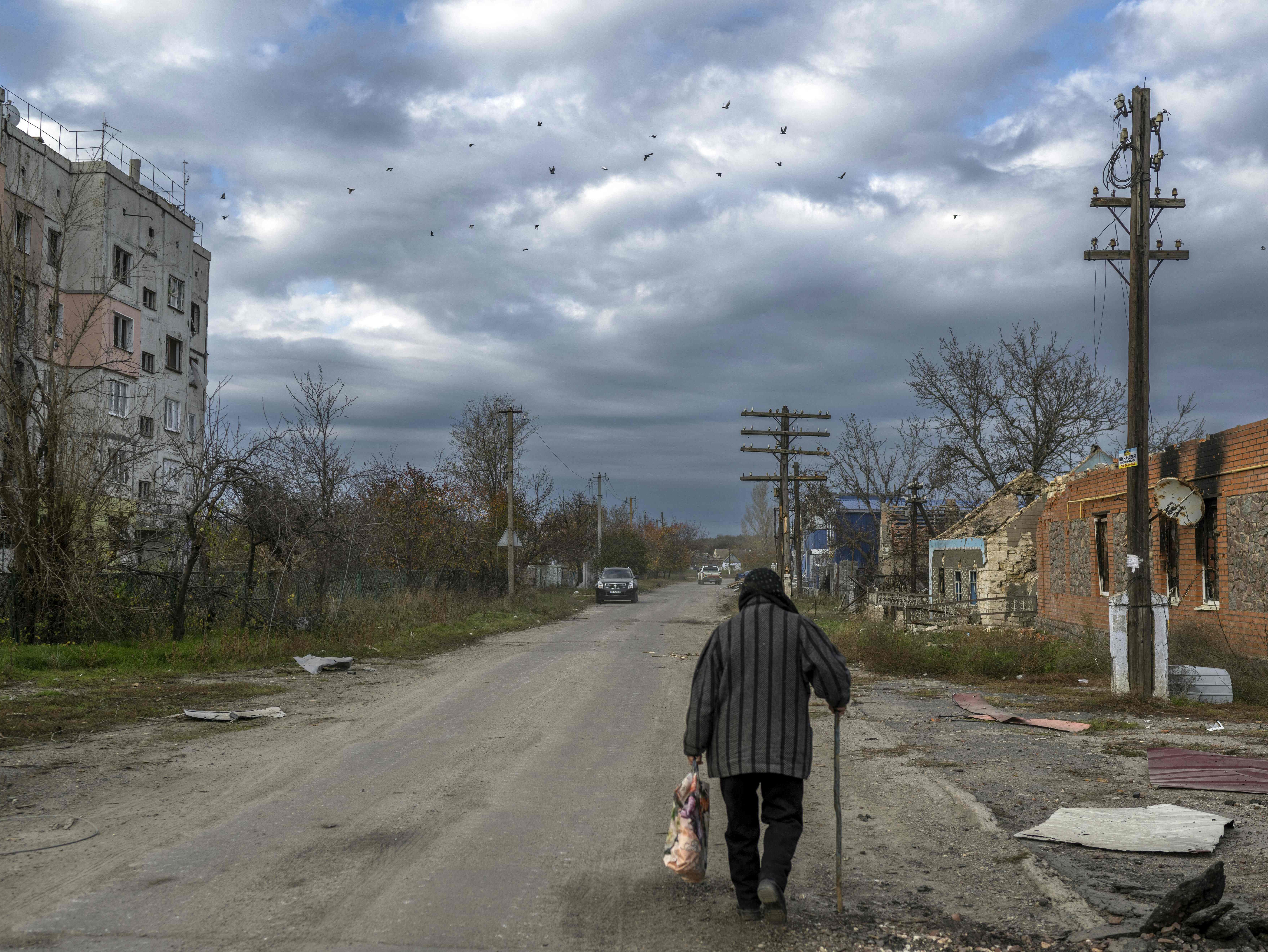 A woman walks in the Kherson region village of Arkhanhelske after the Russian withdrawal