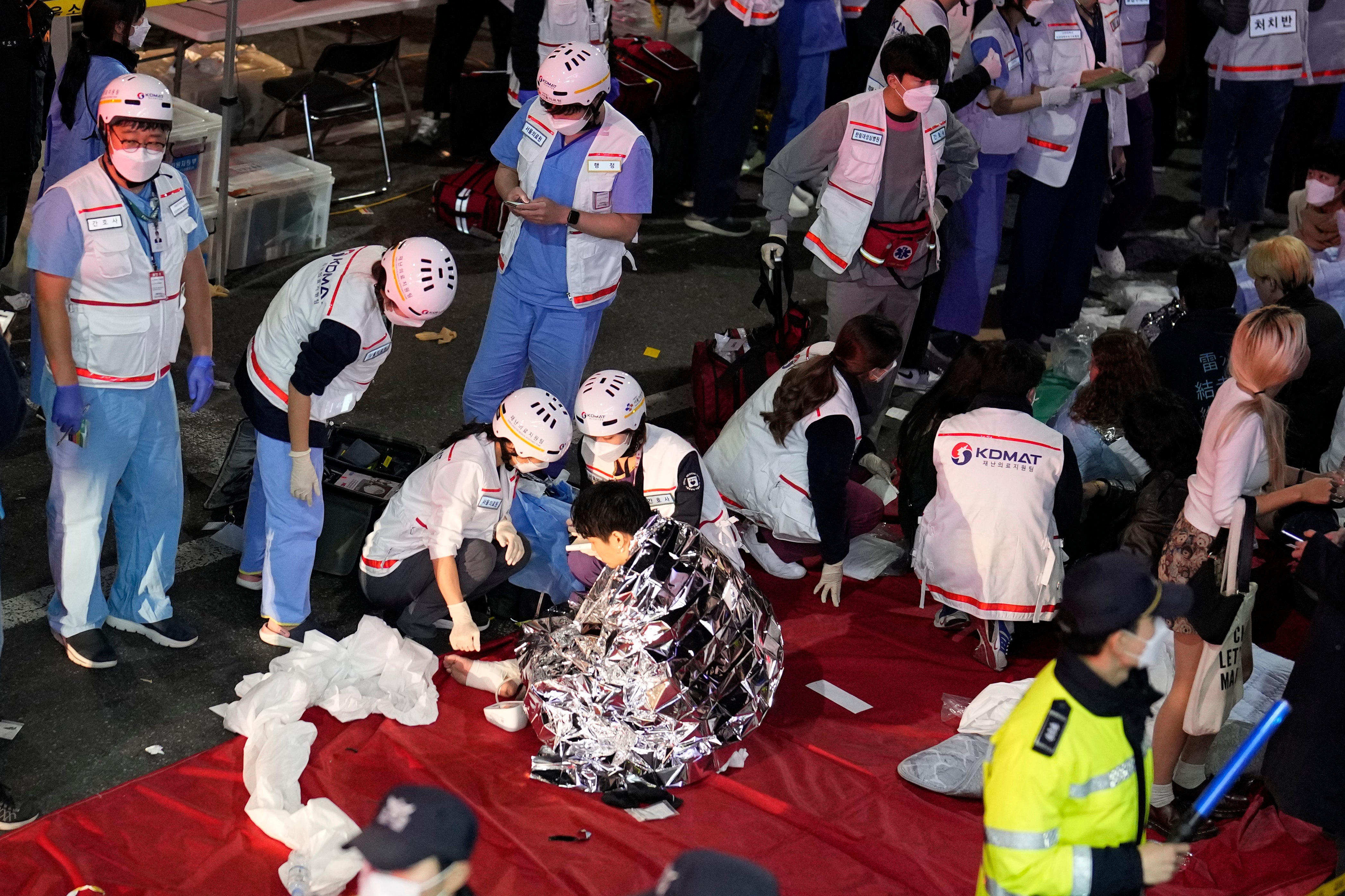 Rescue workers treat injured people on the street in Seoul, South Korea, Sunday, 30 October 2022