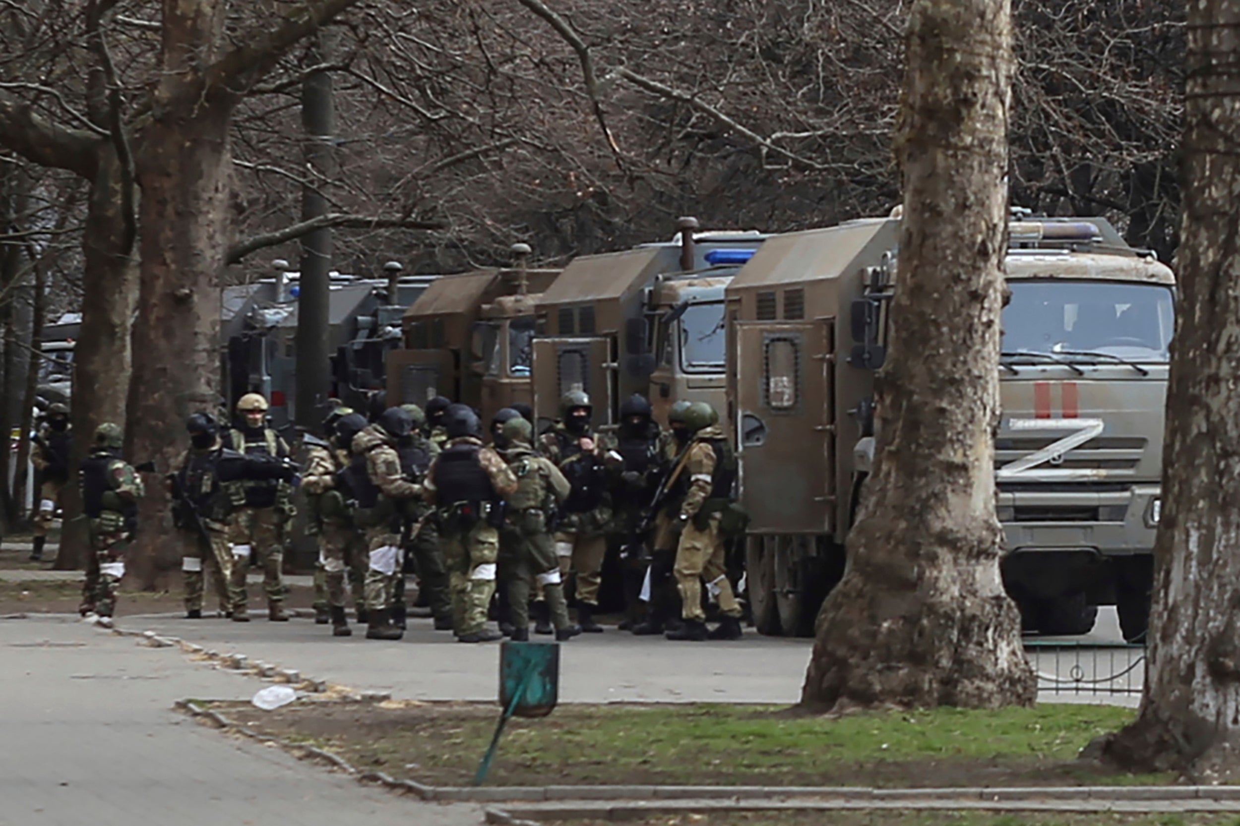 Russian army soldiers stand next to their trucks