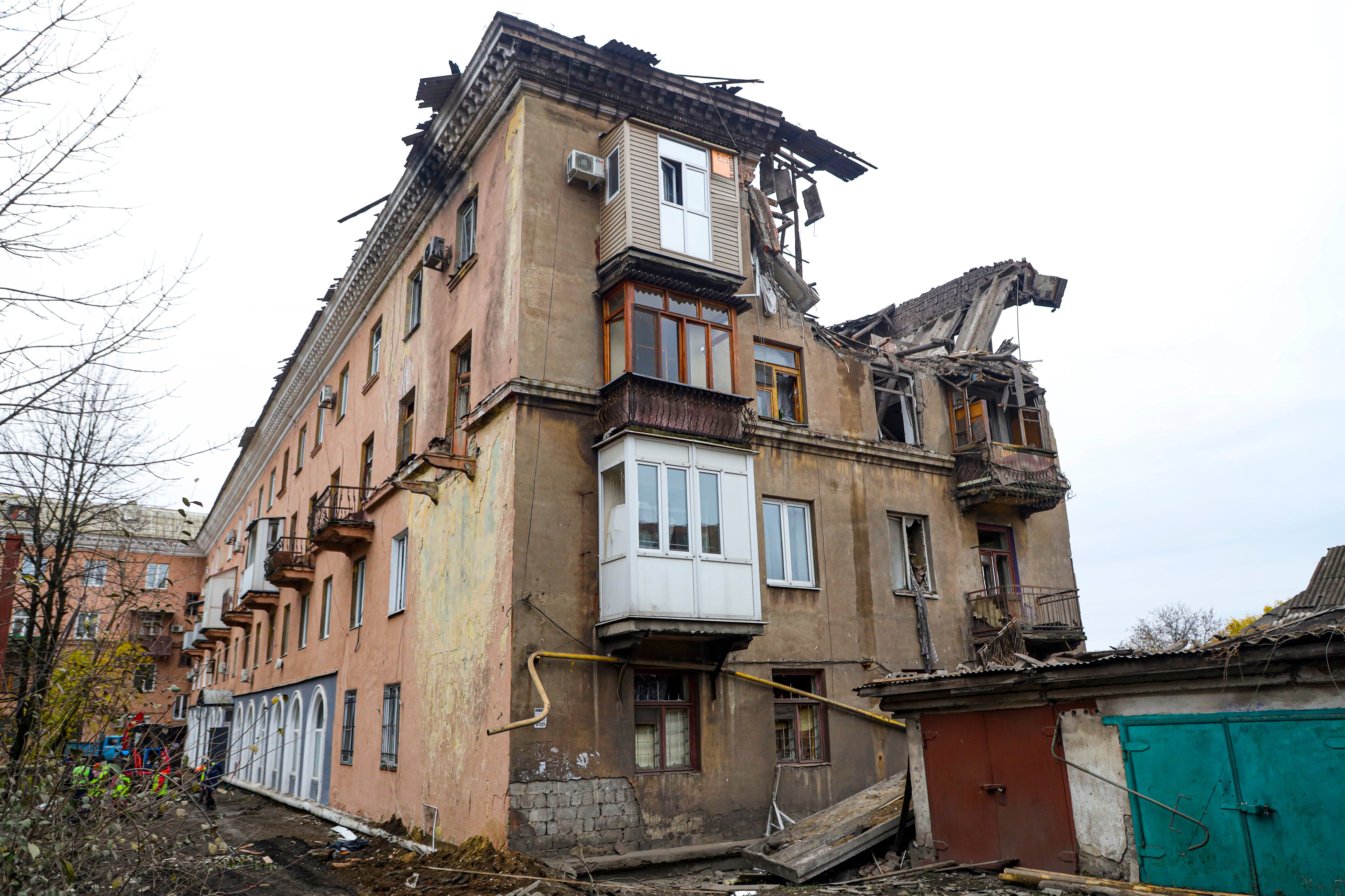 Rescuers, left, work at a site of a damaged apartment building after shelling by Ukrainian forces in Makiivka, Donetsk People's Republic, eastern Ukraine