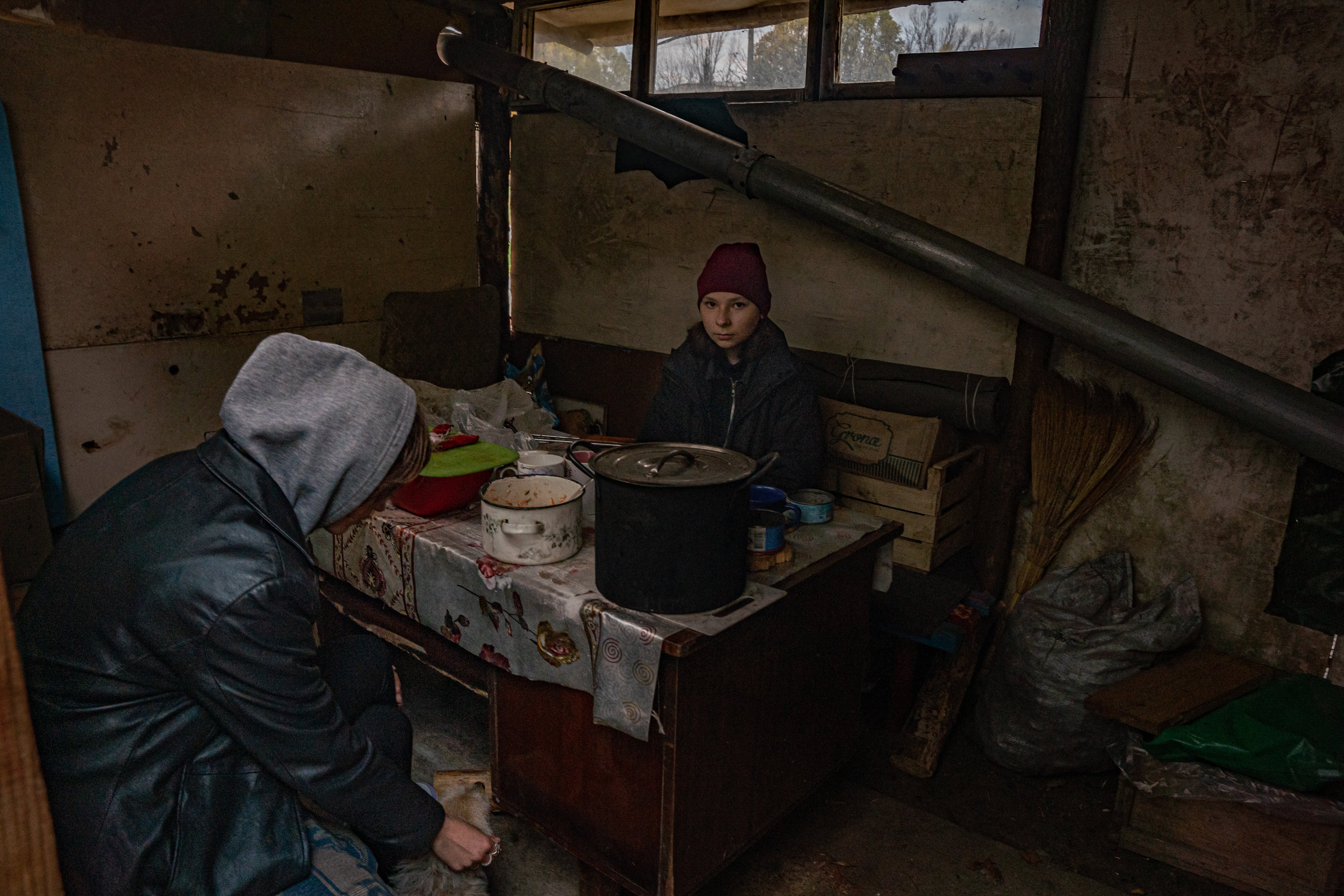 Two sisters sit in a cabin built by Vladimir and Igor, who stayed behind in Kosharivka to look after the elderly and infirm