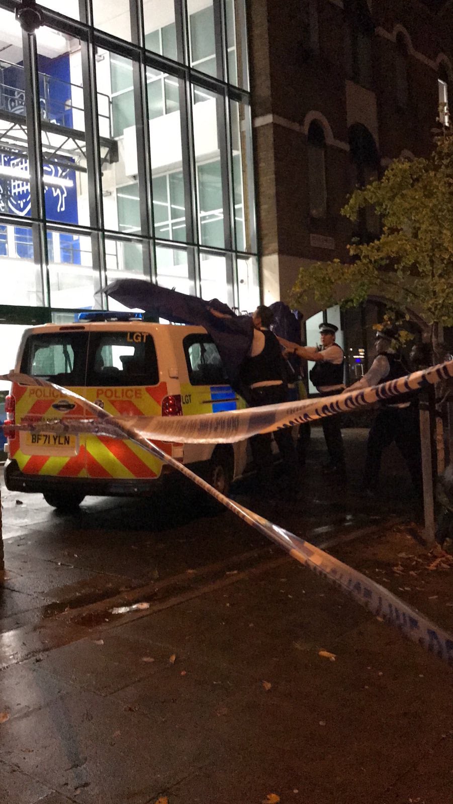 A police van is covered within a cordon outside the station