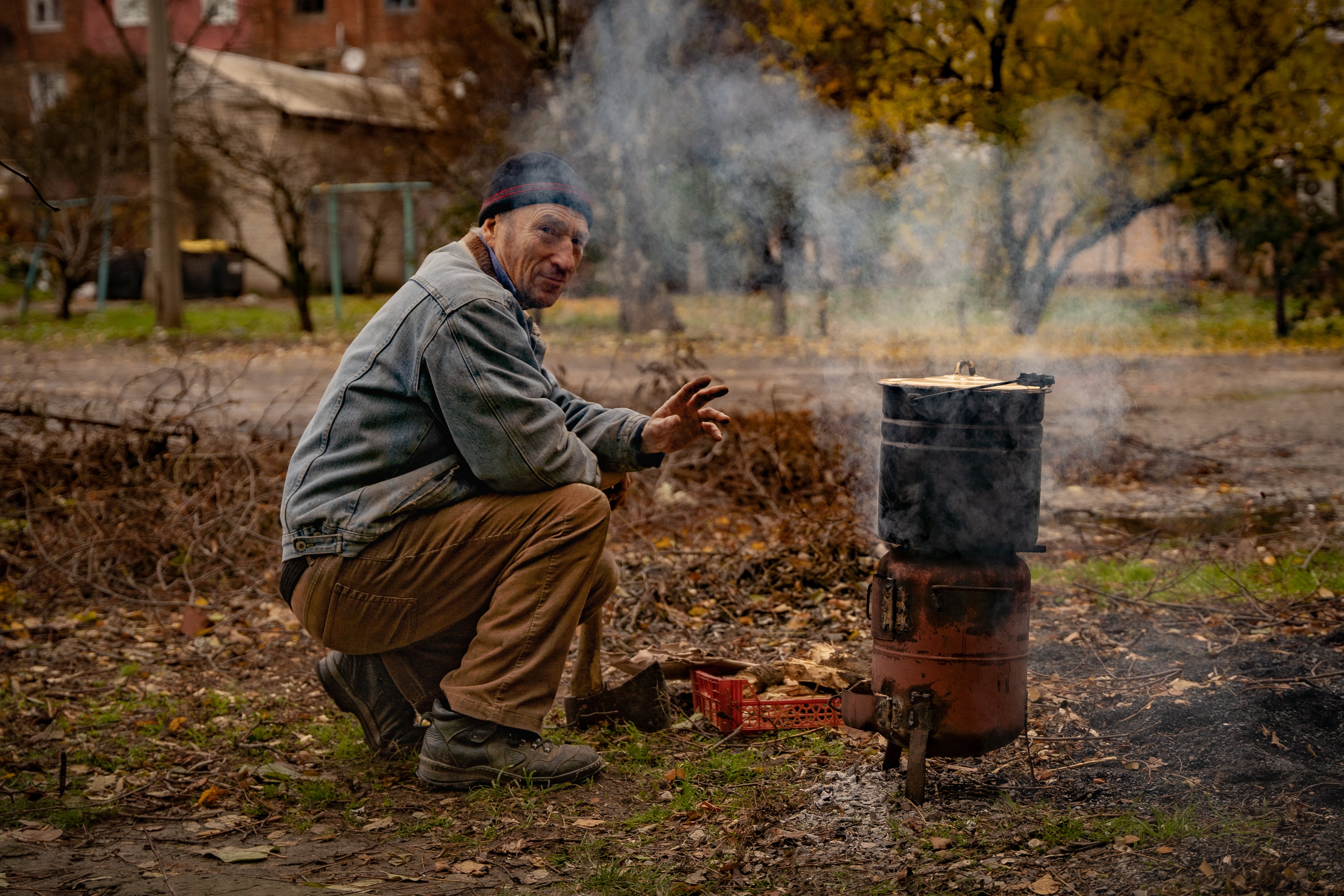 A resident of Bakhmut cooks on a fire outside under shelling in the frontline town, which has little to no access to electricity or water