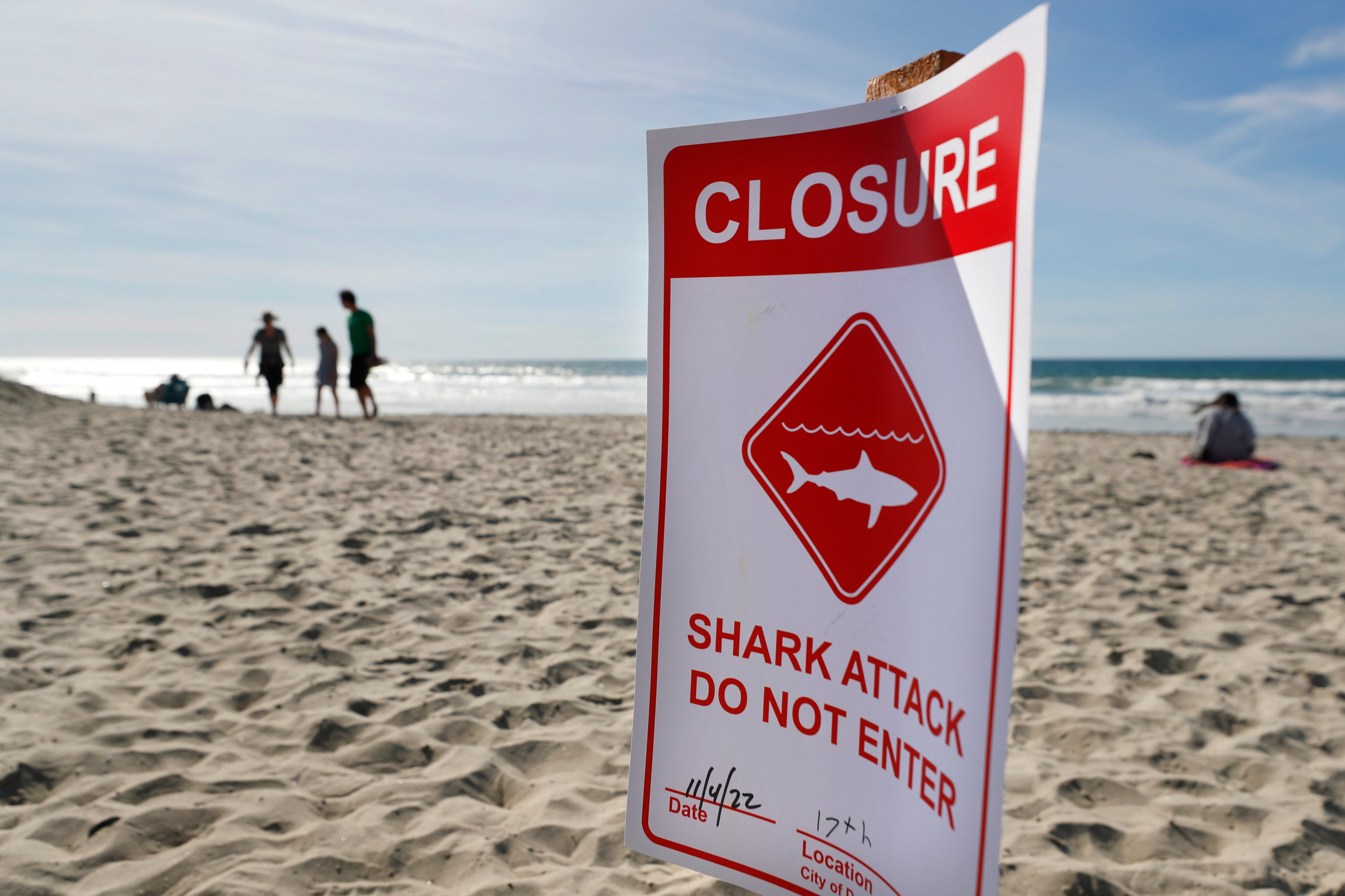 A closure sign is posted off Del Mar beach, north of San Diego, after a 50-year-old woman was bitten by a shark in the water prompting a beach closure of at least 48 hours in the area, city lifeguard officials said on Friday, Nov. 4, 2022